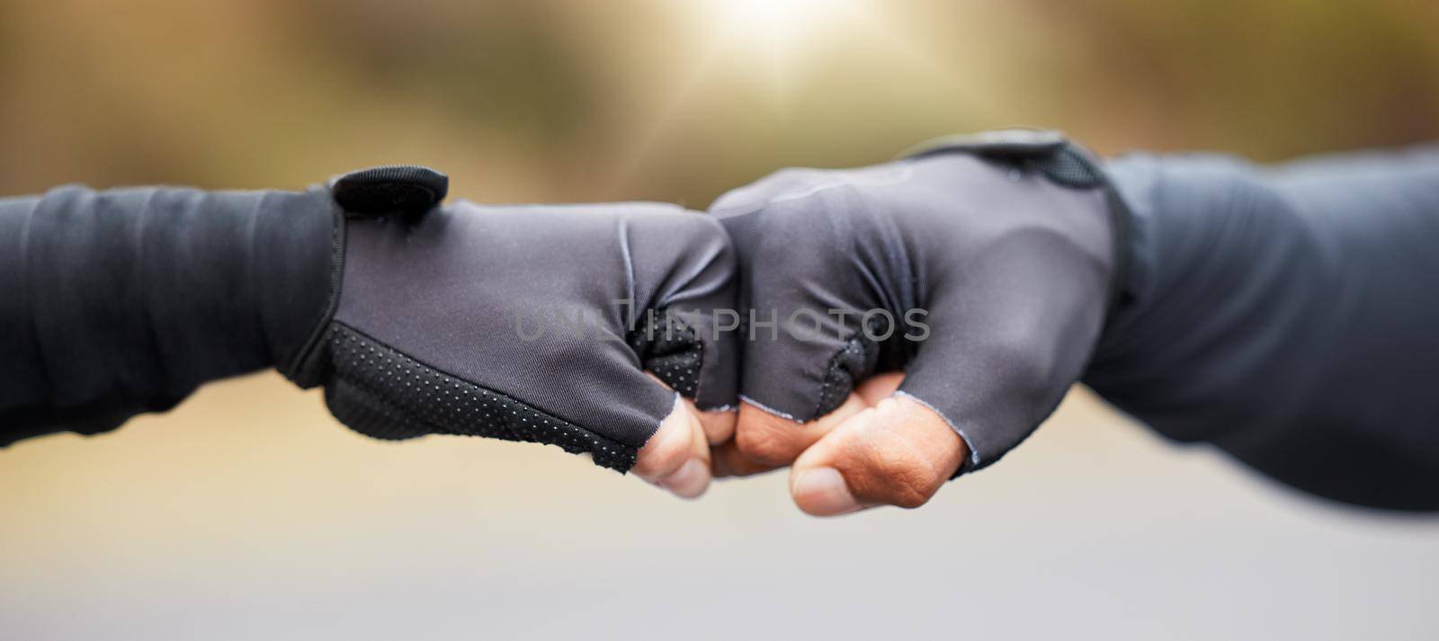 Motivation, teamwork and unity with hands in gloves fist bump to show collaboration, solidarity and working together. Closeup of people showing success, community and achieving a goal as a team by YuriArcurs