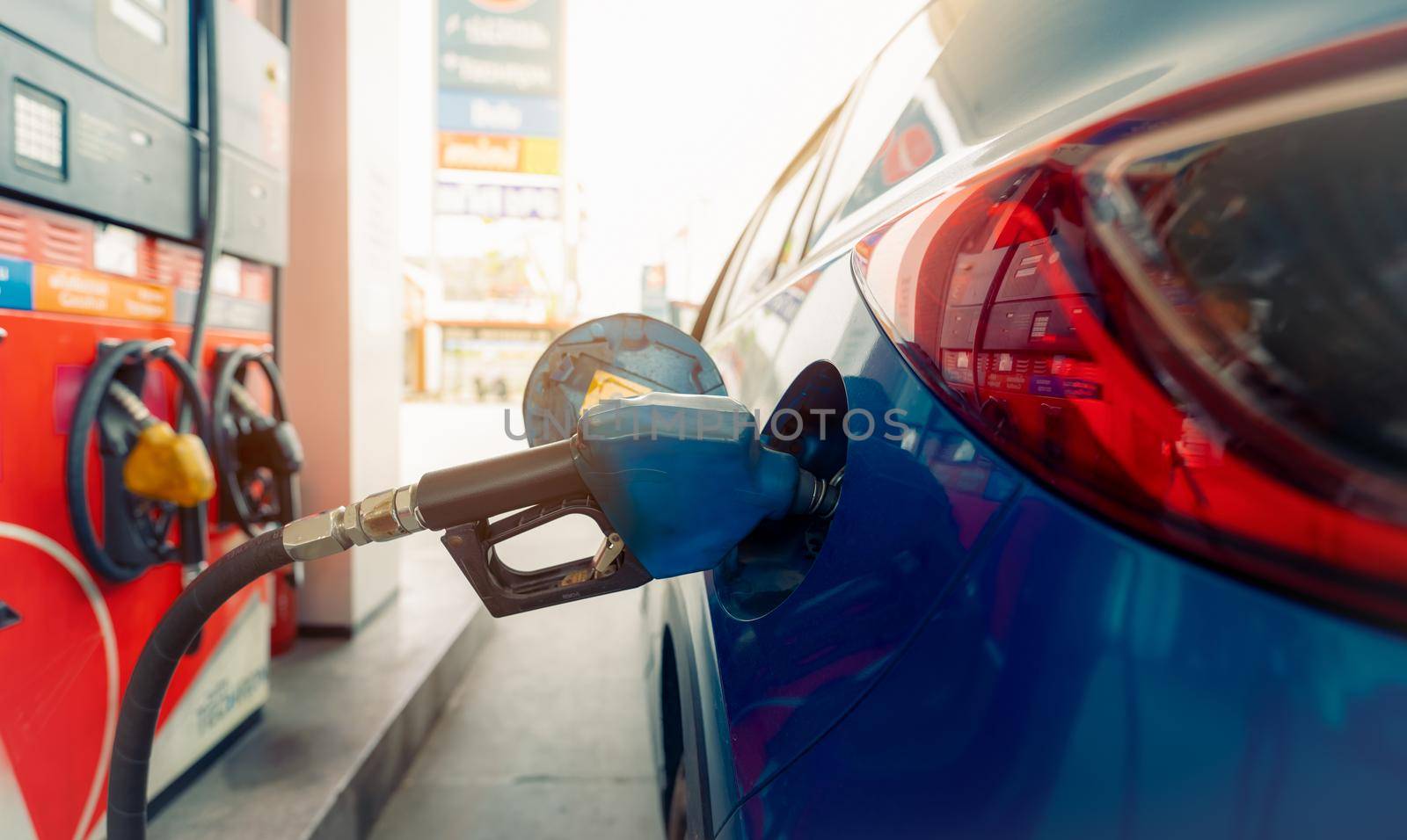 Car fueling at gas station. Refuel fill up with petrol gasoline. Petrol pump filling fuel nozzle in fuel tank of car at gas station. Petrol industry and service. Petrol price and oil crisis concept. by Fahroni