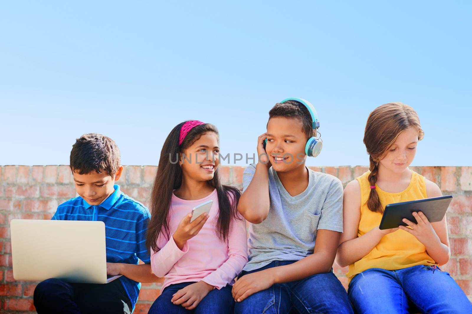 We are the digital age. a diverse group of children having fun with technology outside. by YuriArcurs