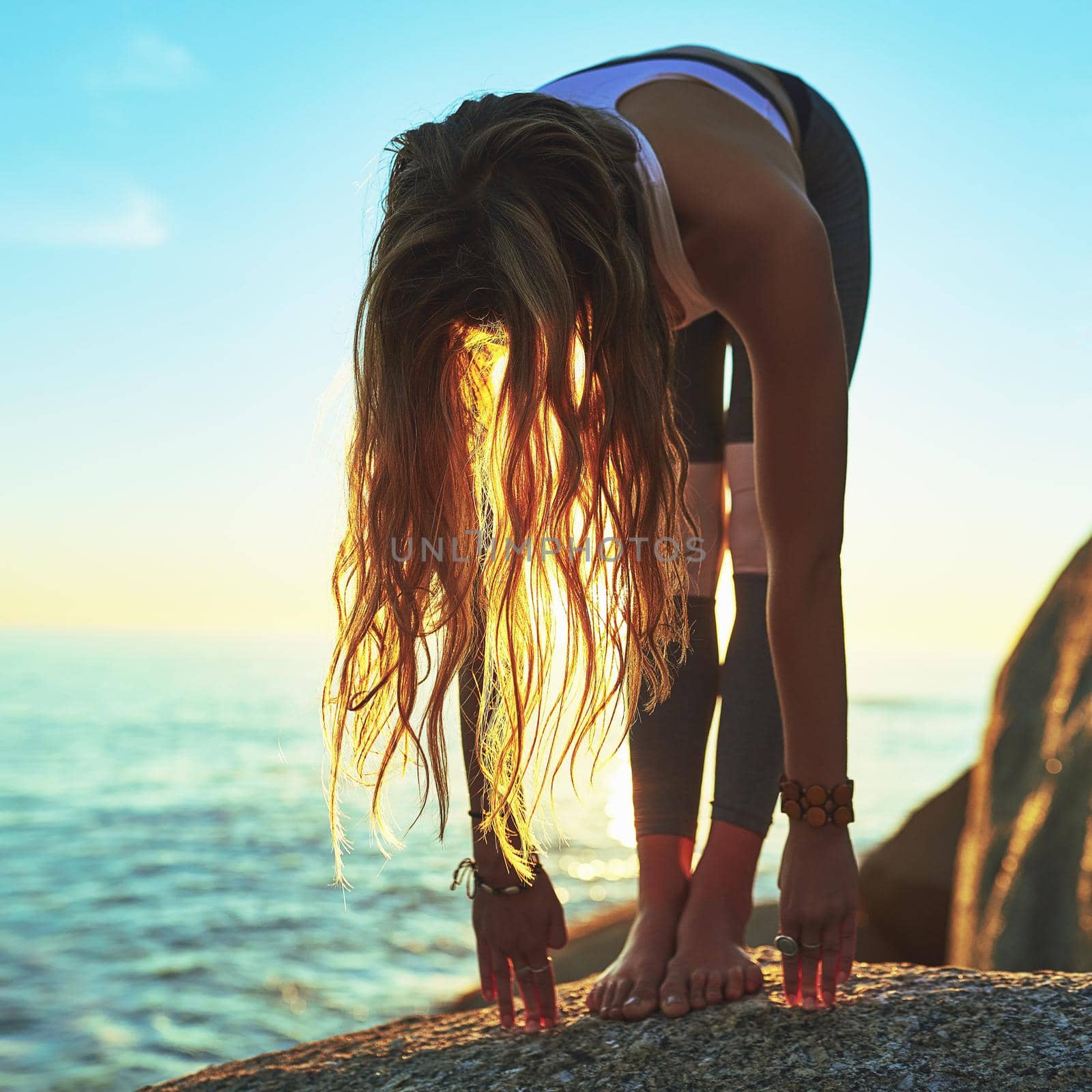Allow yourself to let go. an athletic young woman practicing yoga on the beach