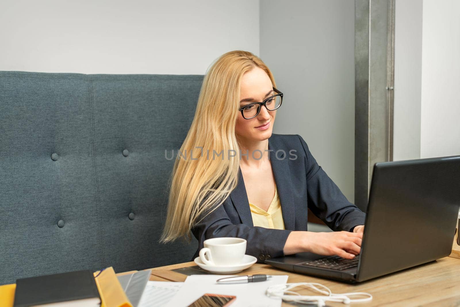 Young businesswoman using laptop sitting at the table in a cafe