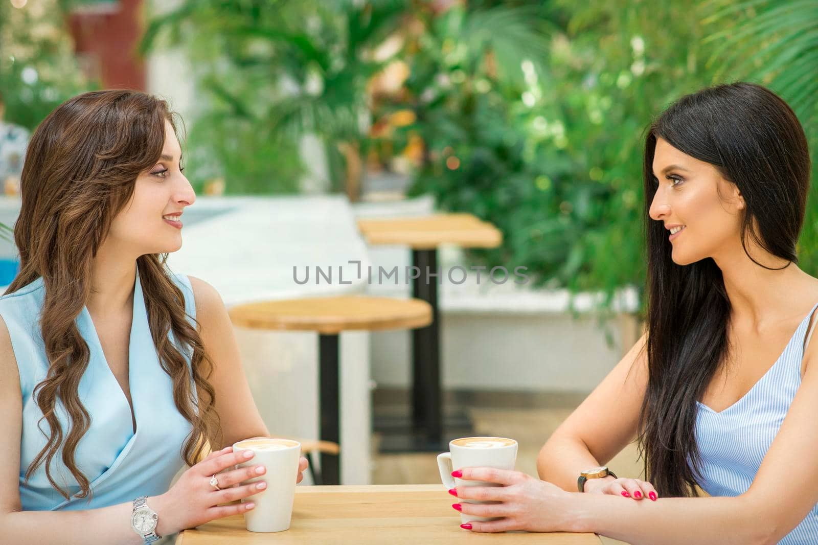 Two young women drink coffee by okskukuruza