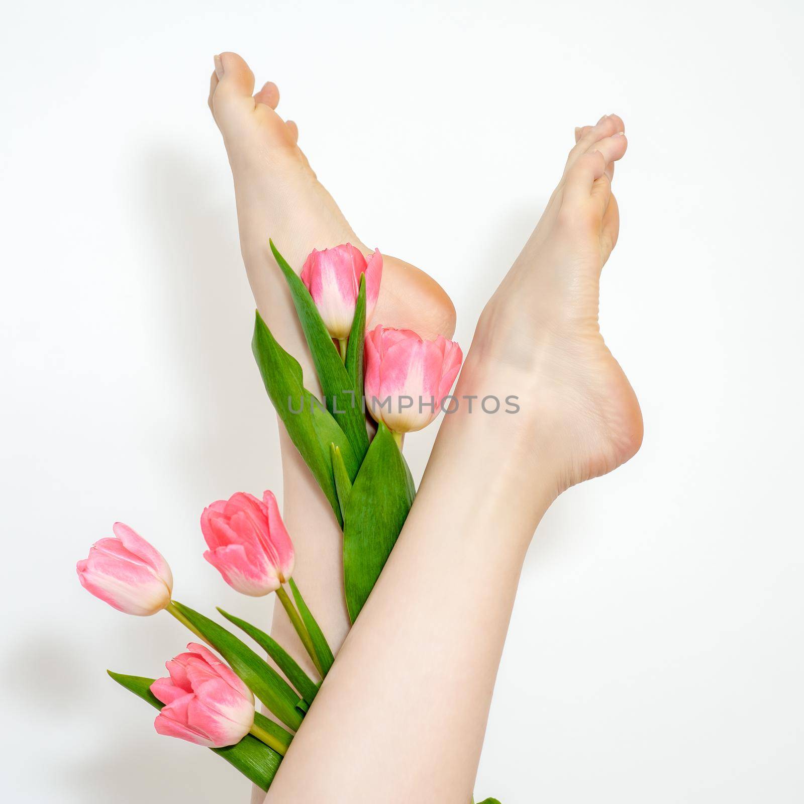 Woman's legs with tulips flowers by okskukuruza
