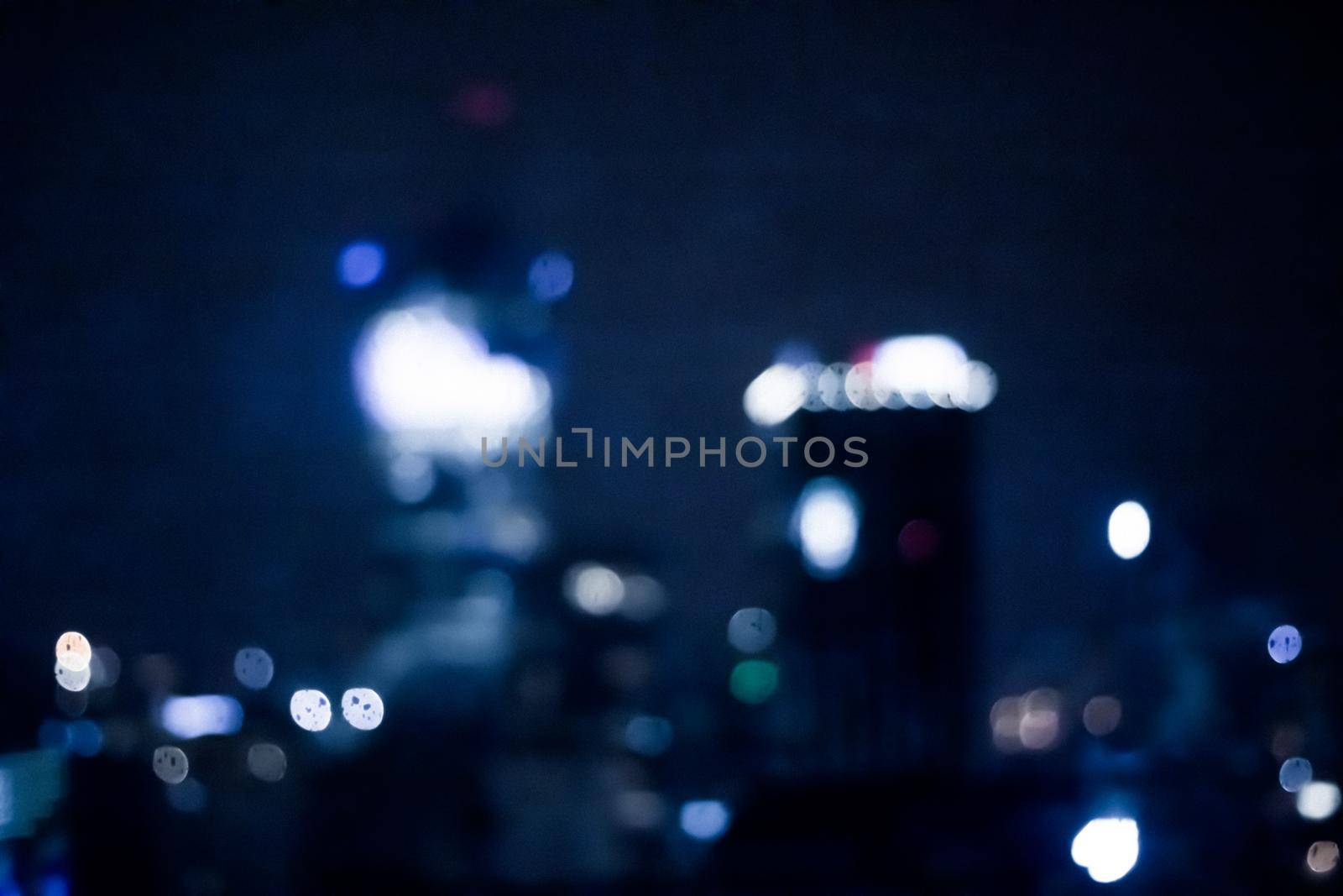 Blurry metropolitan district - night life, abstract background and modern dark tones concept. Big city comes alive at night