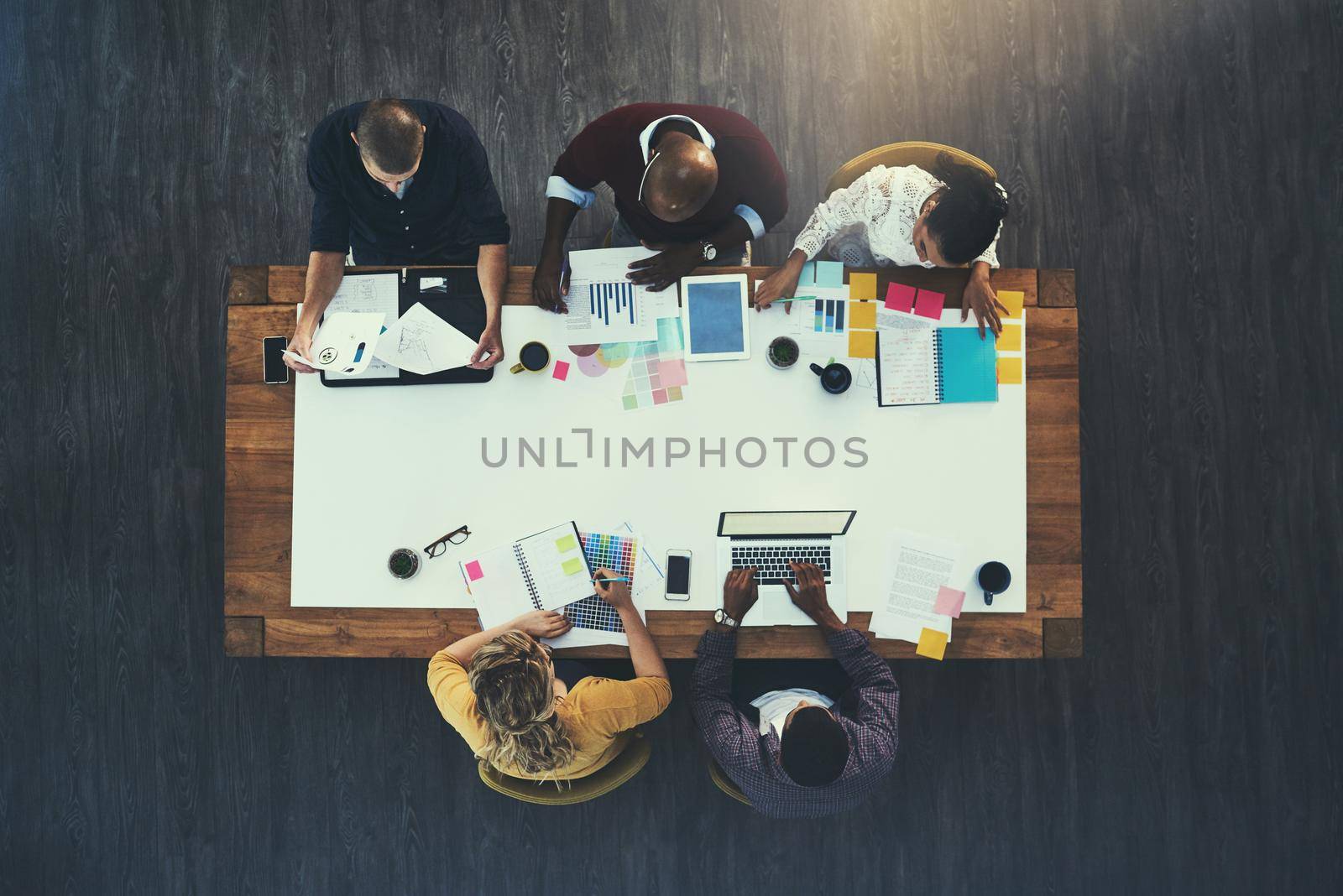 Gathered to make business great. High angle shot of a group of businesspeople having a meeting in a modern office