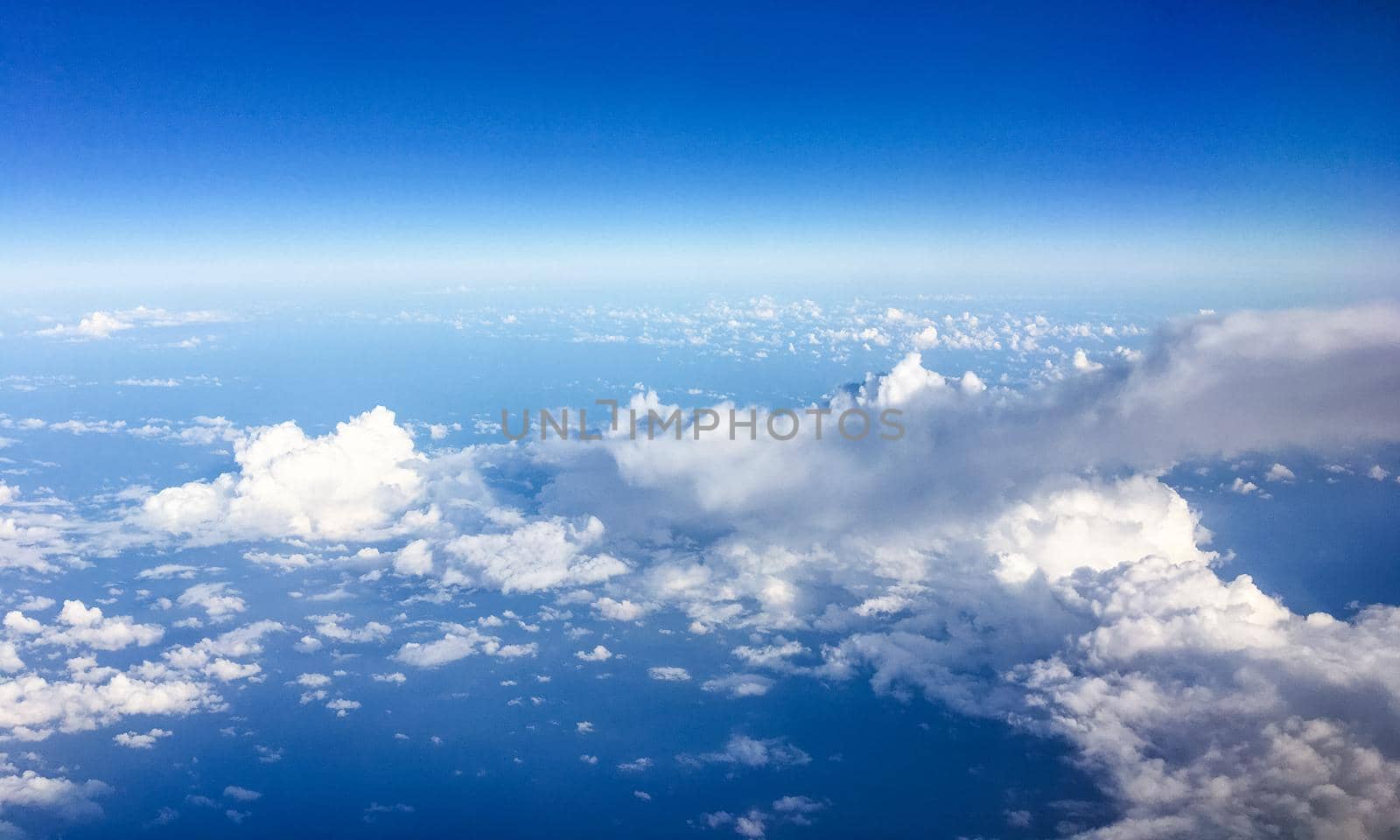 Travel, cloudscape and natural environment concept - View from the airplane window, sky and ocean blue