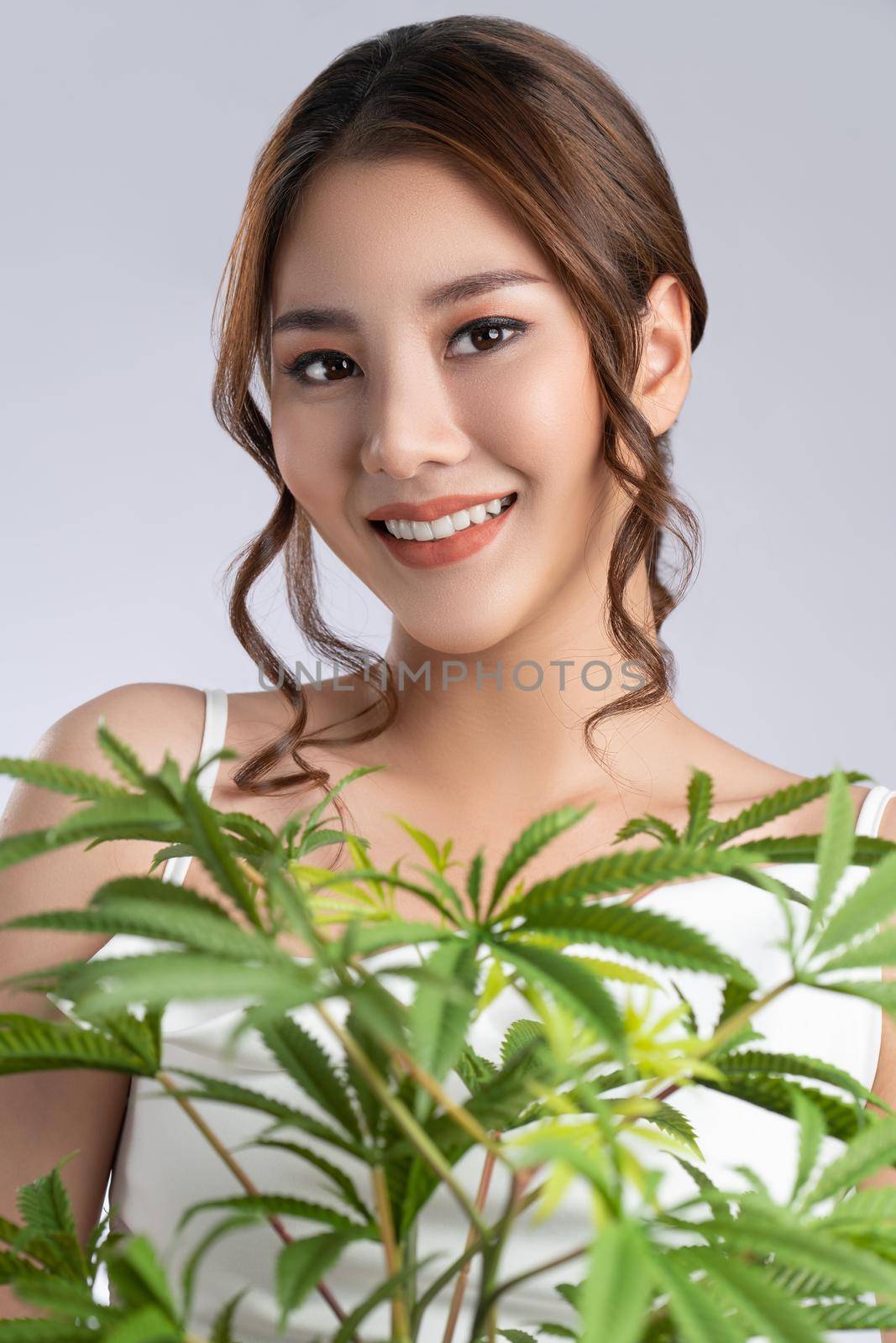 Close up gorgeous girl with healthy fresh skin and makeup holding hemp pot. by biancoblue