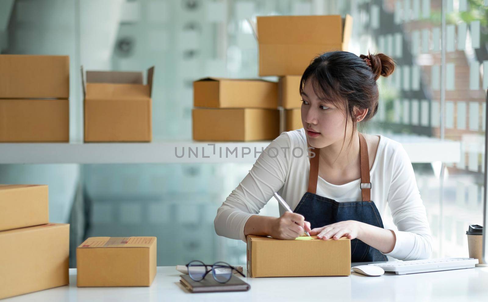 Small start-up business owners using computers and phones at work, salespeople, checking production orders. Pack products to ship to customers, sell ecommerce shipping ideas..