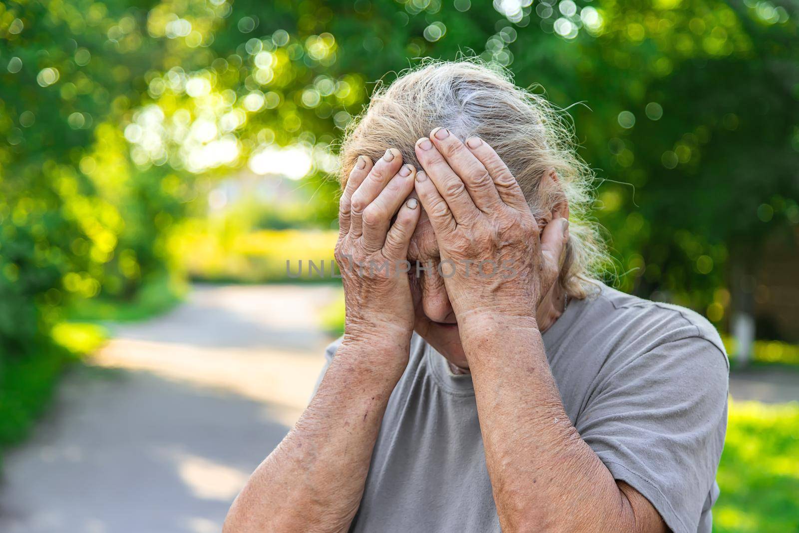 grandmother has a headache on the road. Selective focus. hurts