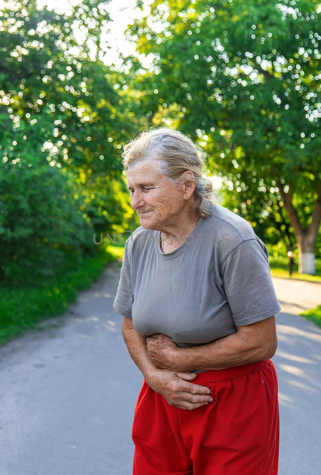 grandmother has a stomach ache on the road. Selective focus. people.