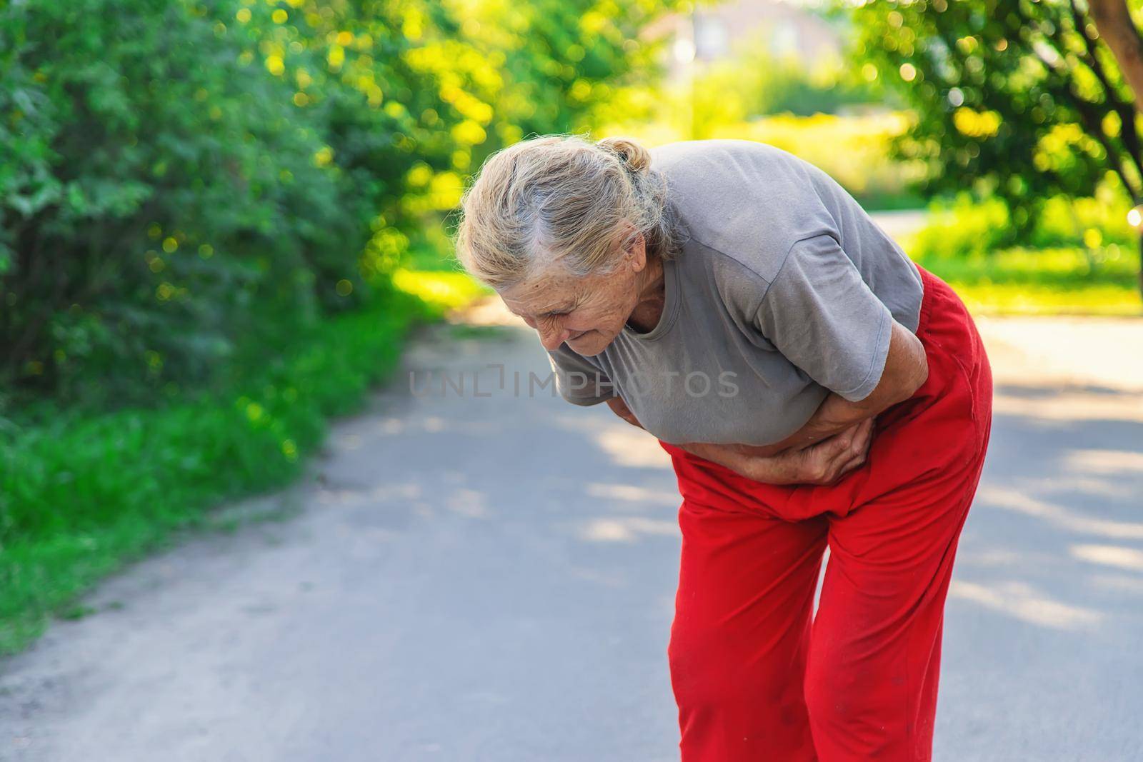 grandmother has a stomach ache on the road. Selective focus. people.