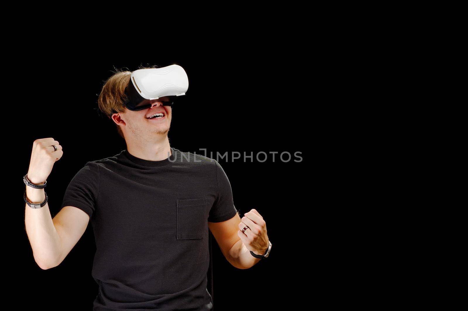 Portrait of a young man with 3D virtual reality glasses. Young man using white virtual reality headset, VR, future, goggles, technology concept on black background.