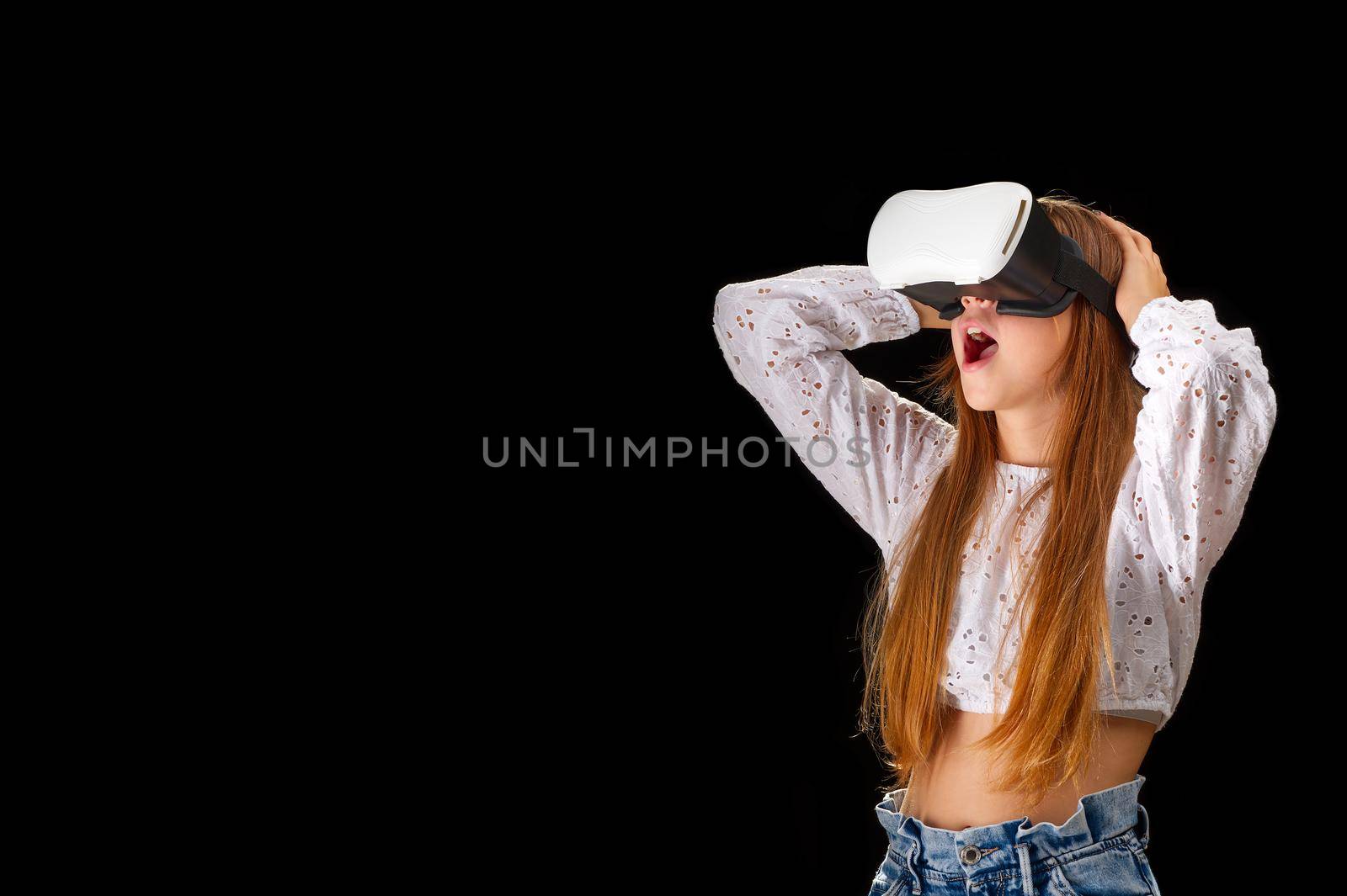 Portrait of young Caucasian woman using virtual reality with holographic hololens glasses, googles. Future technology concept on black background. education and gaming in metaverse.