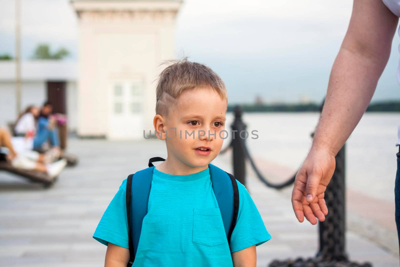 A boy in a blue T-shirt with a backpack on his back. Journey.  The face expresses natural joyful emotions. Not staged photos from nature.