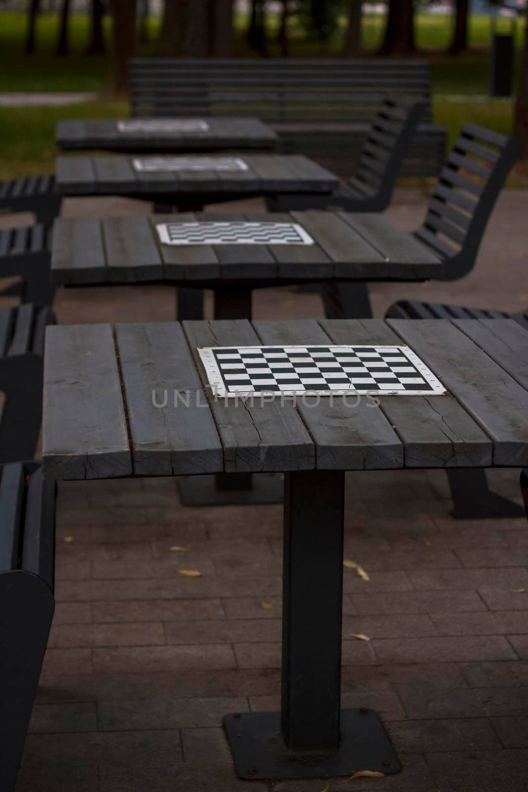 There are chess tables for everyone in the park. City playgrounds