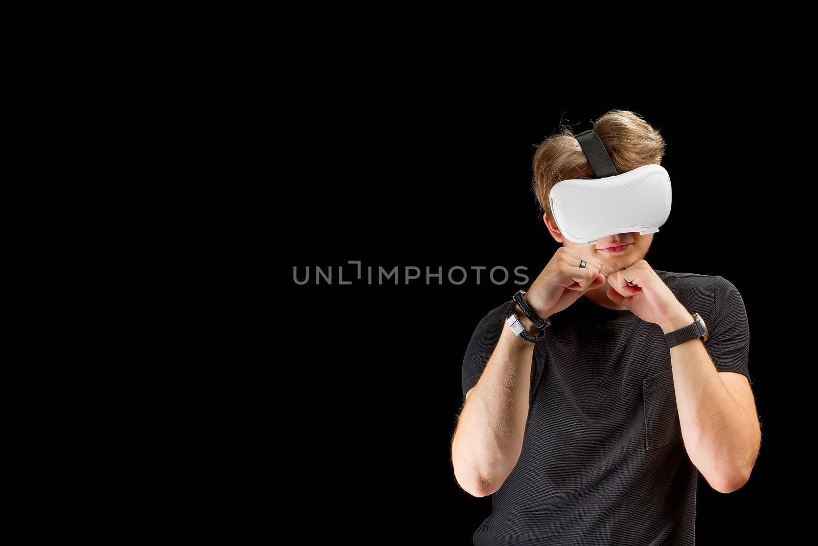Young man wearing virtual reality VR glasses, goggles isolated on black background. Inside A Metaverse games and education concept.