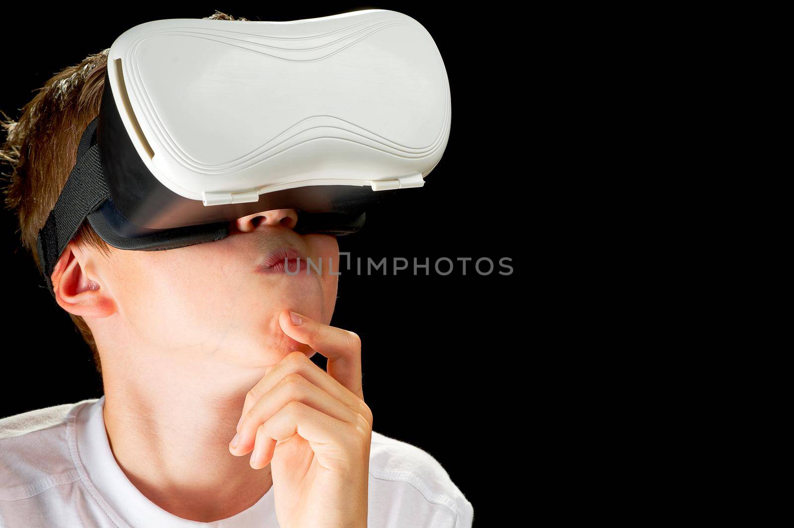 Portrait of young Boy playing VR game in black background. Young hipster wearing VR headset, half body shot. Young generation choose virtual reality, metaverse relaxation concept. remote education concept