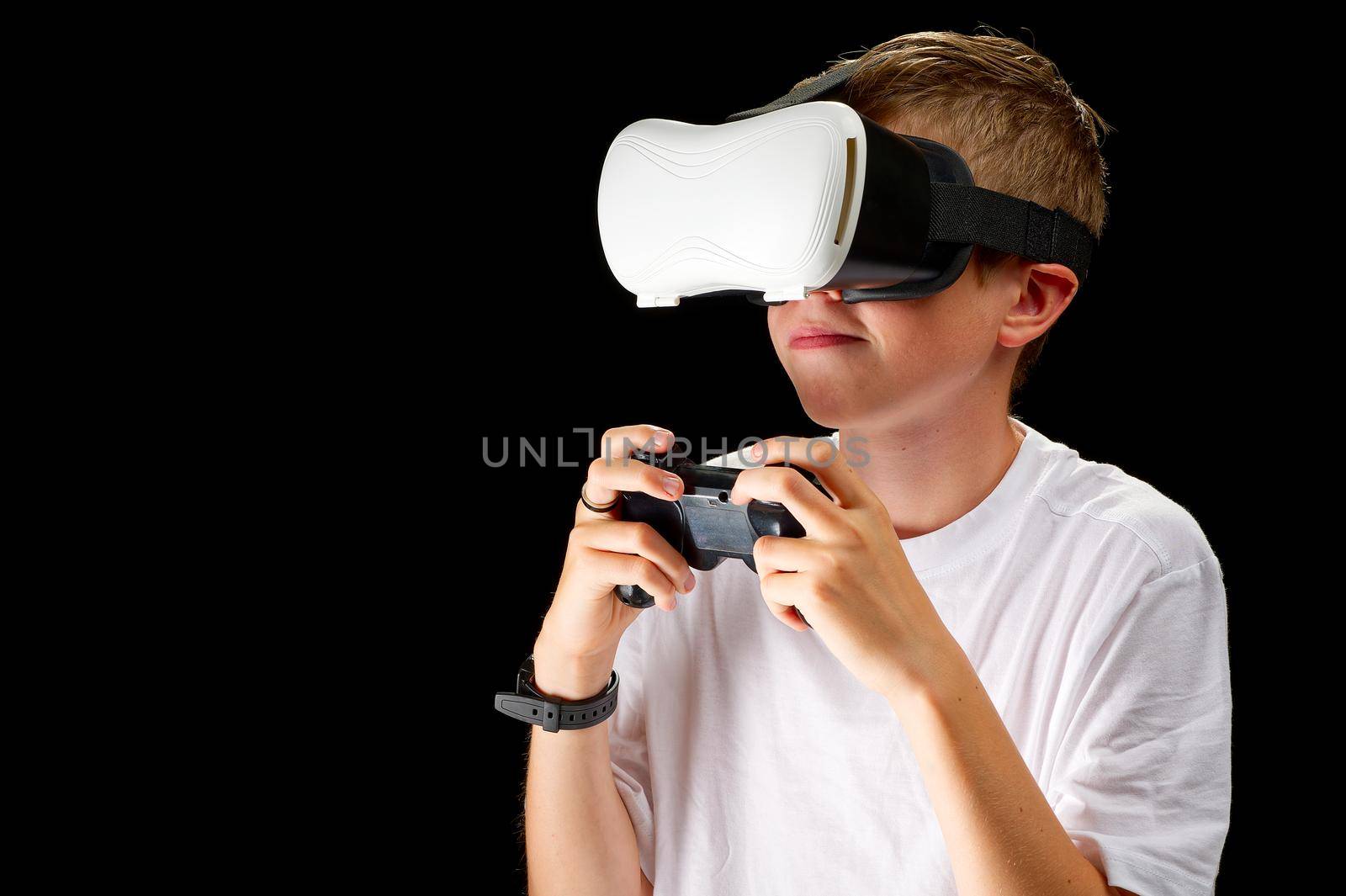 VR Goggles used by a child. Concept of new technology, gaming, remote education, virtual reality. Metaverse world through VR glasses. boy in Virtual reality headset isolated on black background