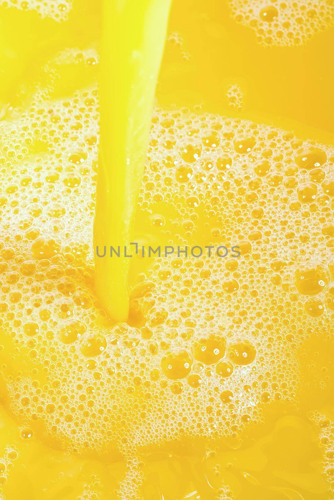 Closeup of splashing orange juice, top view. Splash of fresh sweet orange, mango, fruit juice. by PhotoTime