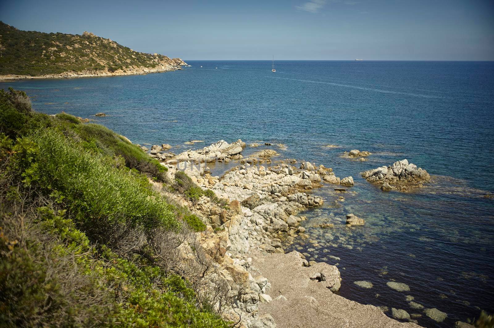 Natural inlet between the mountains and the sea in the south of Sardinia with the outline of a typical Mediterranean vegetation that grows spontaneously on the rocky walls.