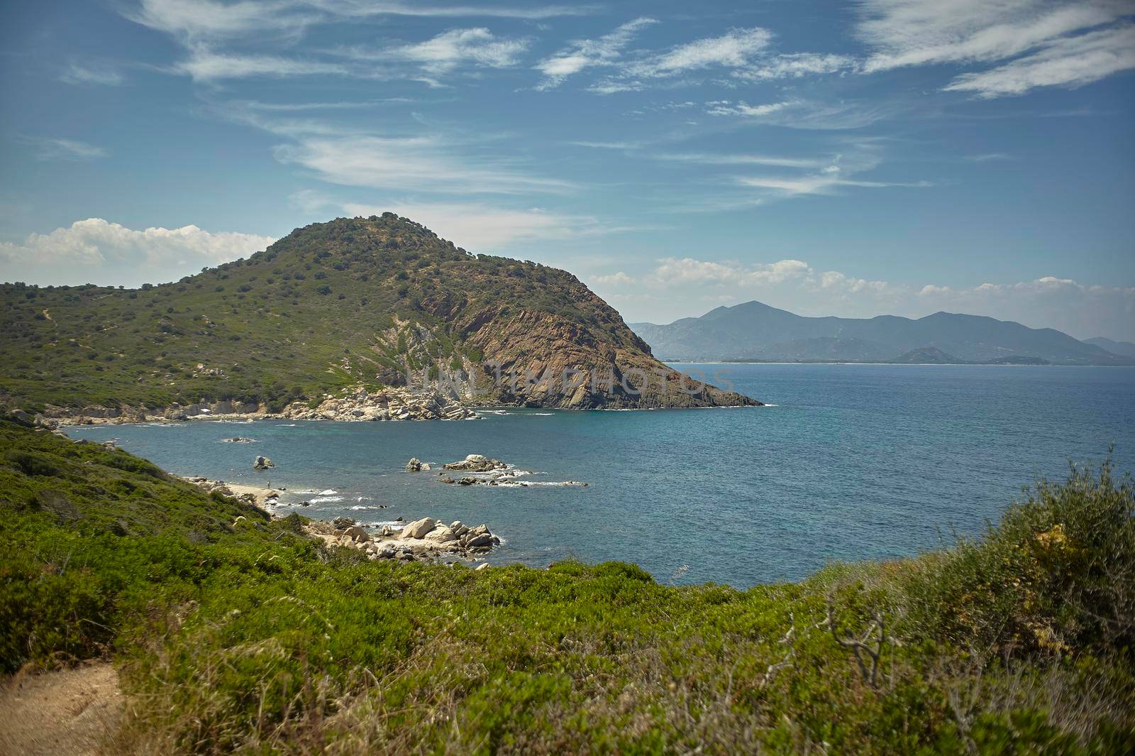 Natural inlet between the mountains and the sea in the south of Sardinia with the outline of a typical Mediterranean vegetation that grows spontaneously on the rocky walls.