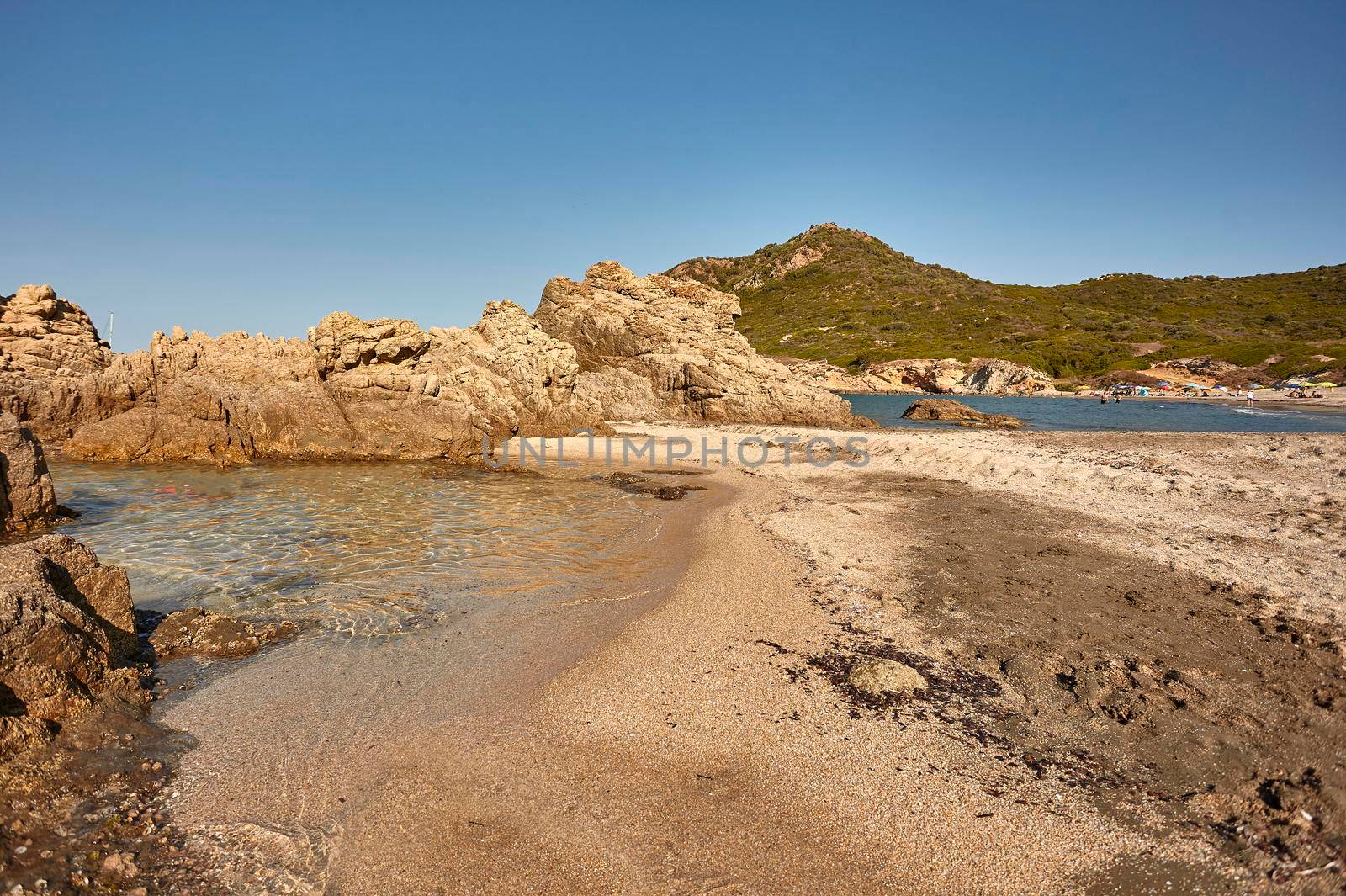 Beautiful aerial view of the Cala Sa Figu beach in Sardinia with its crystal clear sea that meets the colored sand in a spectacular background of the rocky mountains typical of that coast.