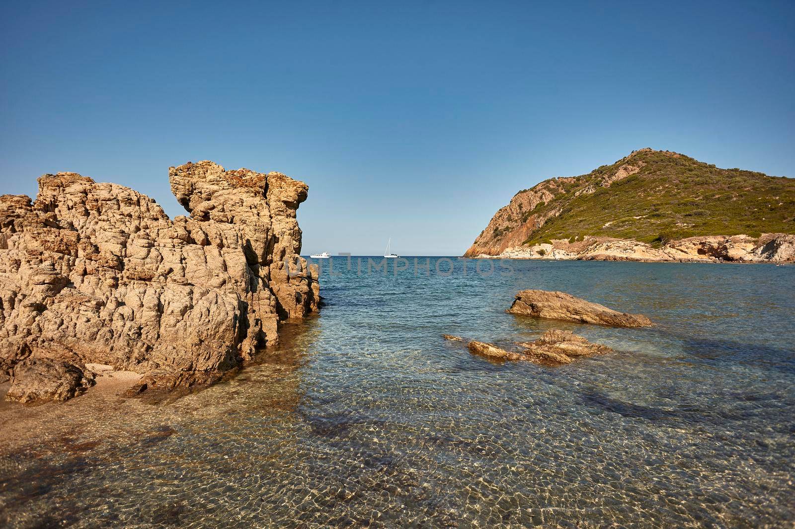 Panorama of rocks escaping from the water in Cala Sa Figu beach in Sardinia, Italy.