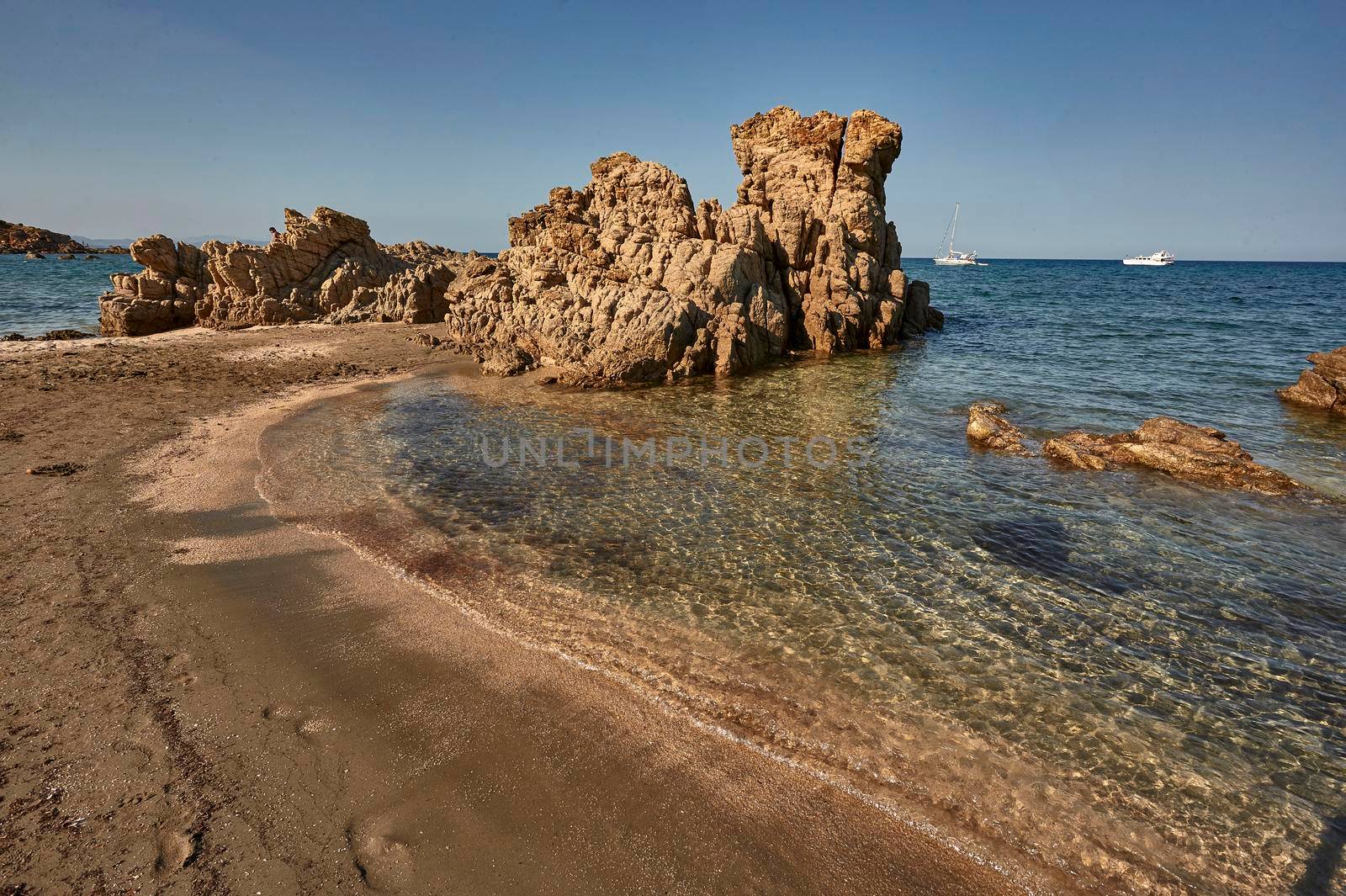 Deserted rocky small beach of southern Sardinia during an August summer afternoon.