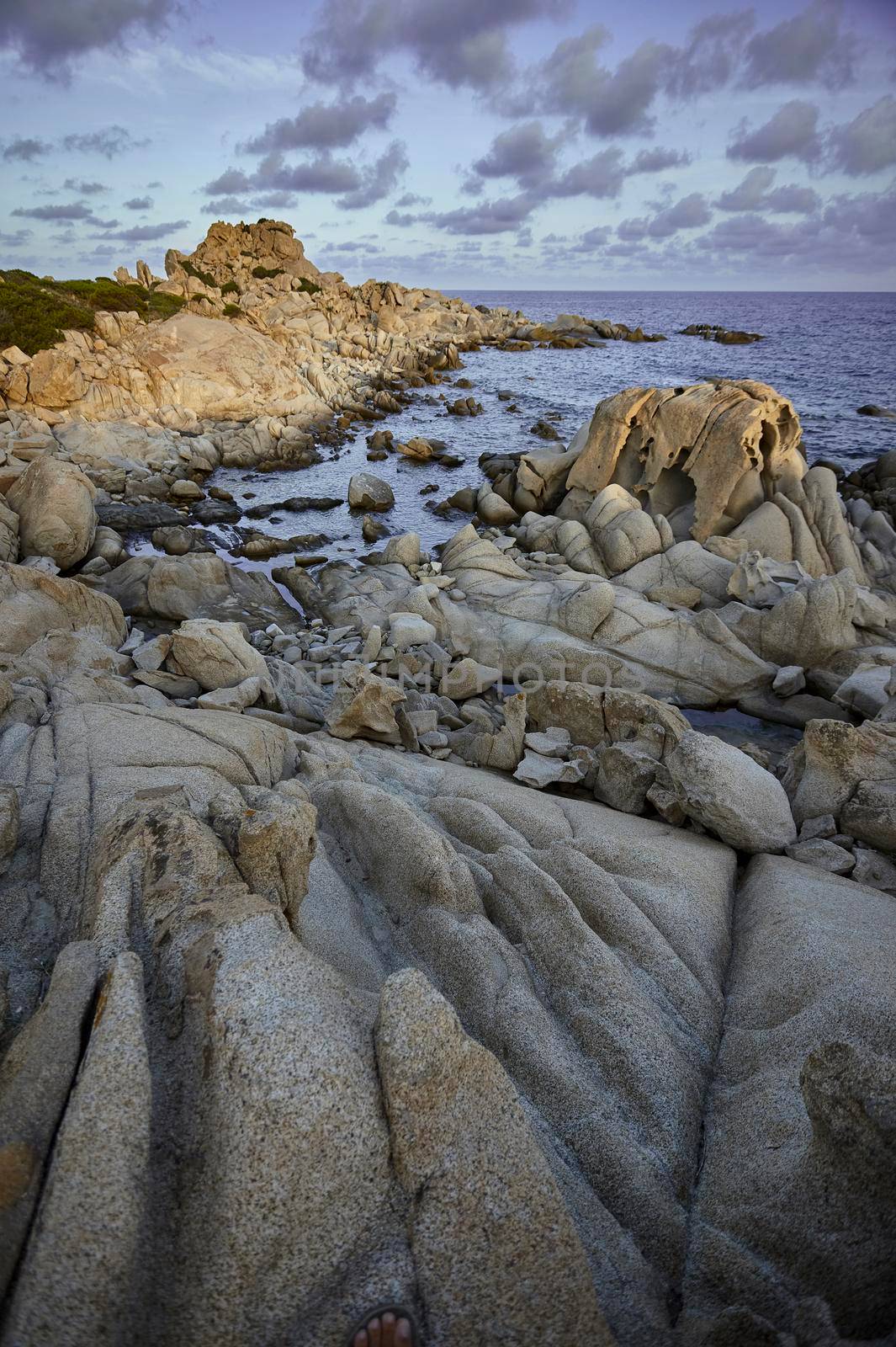 Beautiful cliff on the southern coast of Sardinia, formed by granite rock shaped by the sea and the elements. Vertical Shot.