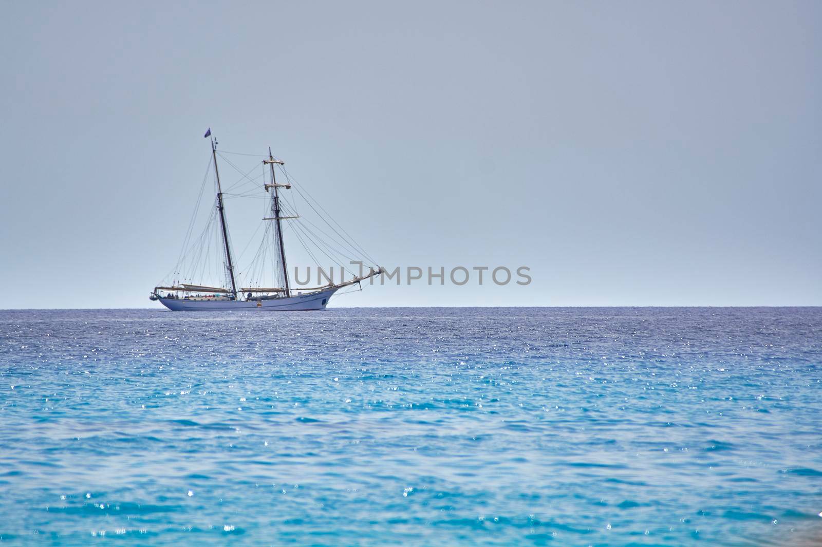 Wonderful vessel navigates on the crystalline and blue sea on the horizon line.