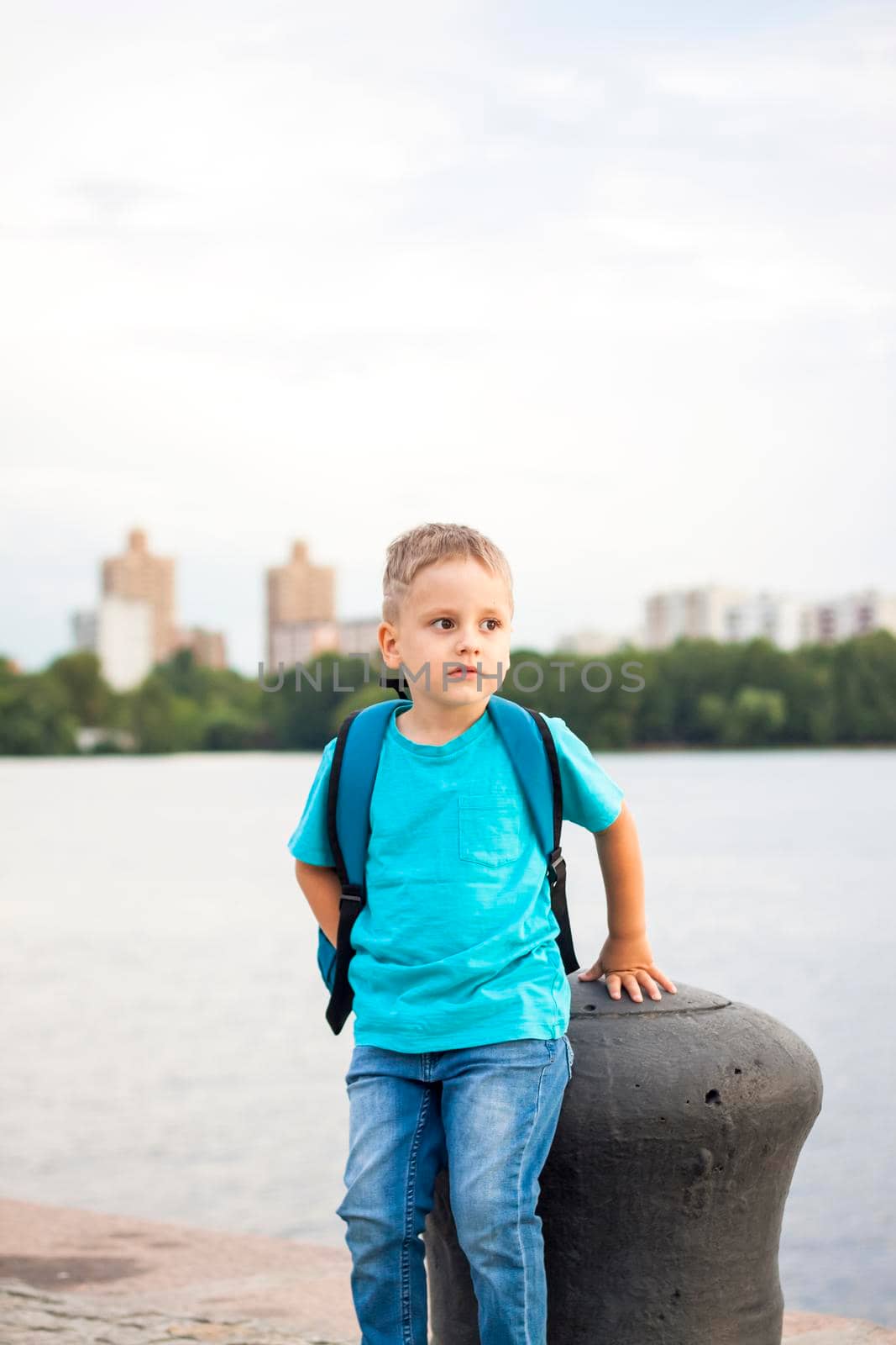 A boy in a blue T-shirt with a backpack on his back. Journey.  The face expresses natural joyful emotions. Not staged photos from nature.