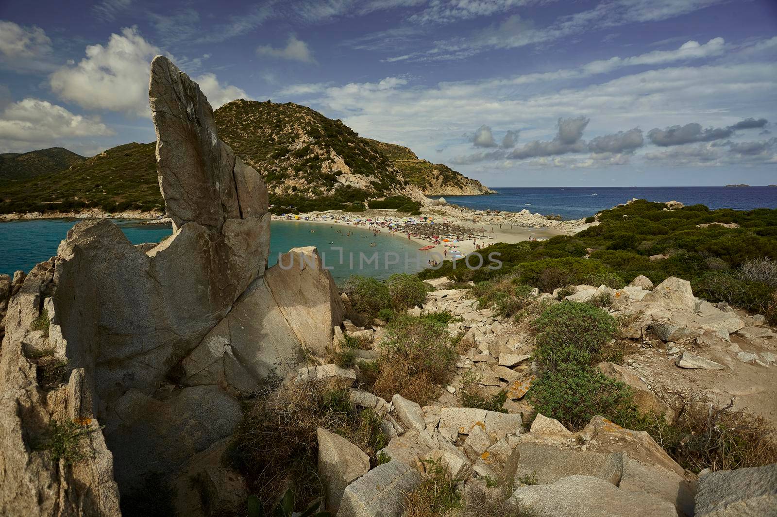 View of Punta Molentis beach from the top of a natural rocky promontory during the summer.