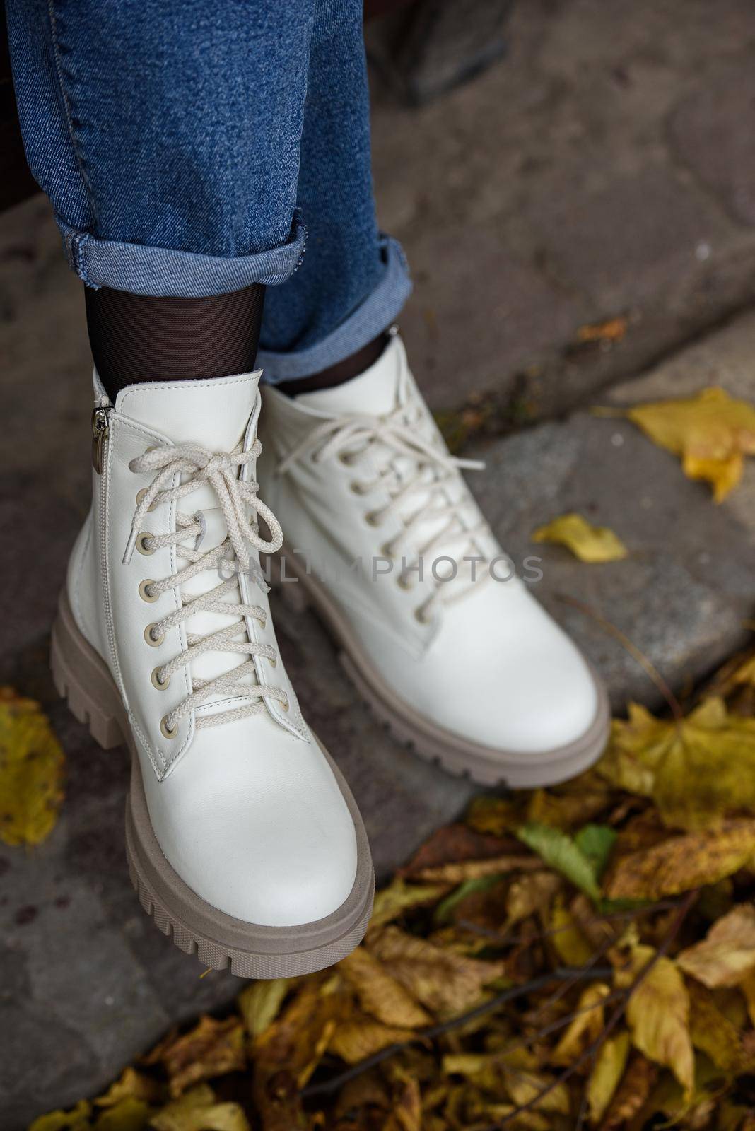 Female legs in a jeans and white fashion boots with laces. by Ashtray25