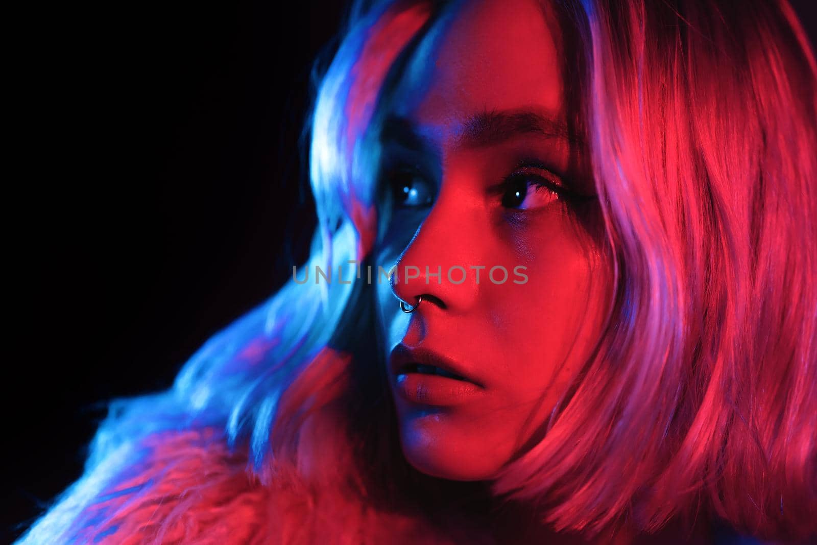 Young woman in pink and violet neon light. Portrait of unusual beautiful glamour and fashion girl with colorful hairstyle on studio background. by kristina_kokhanova