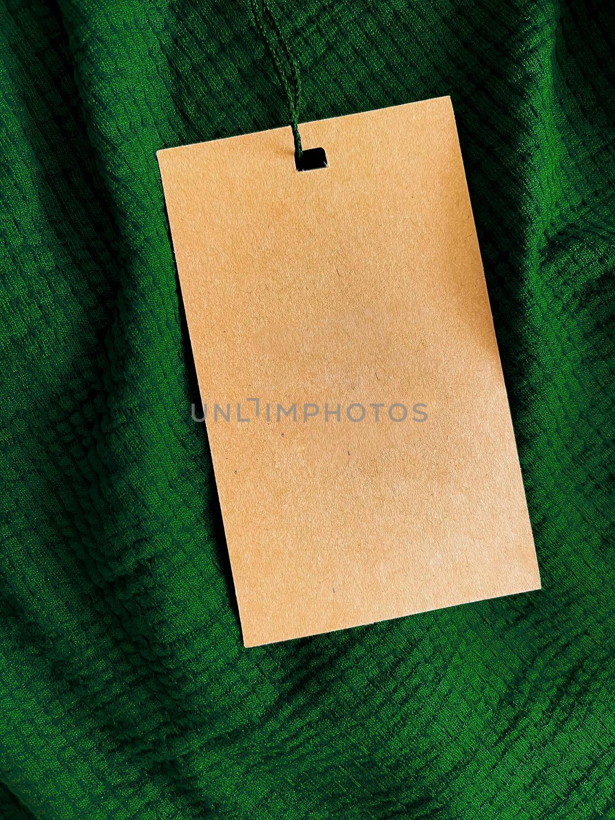 Blank fashion label tag, sale price card on luxury fabric background, shopping and retail concept