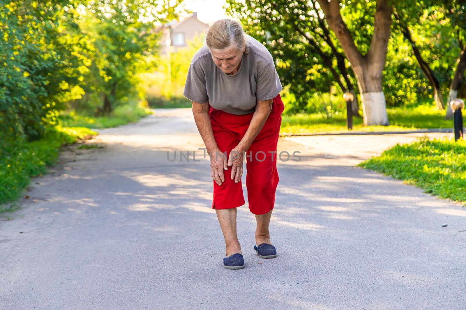 grandmother hurts her knee on the road. Selective focus. People.