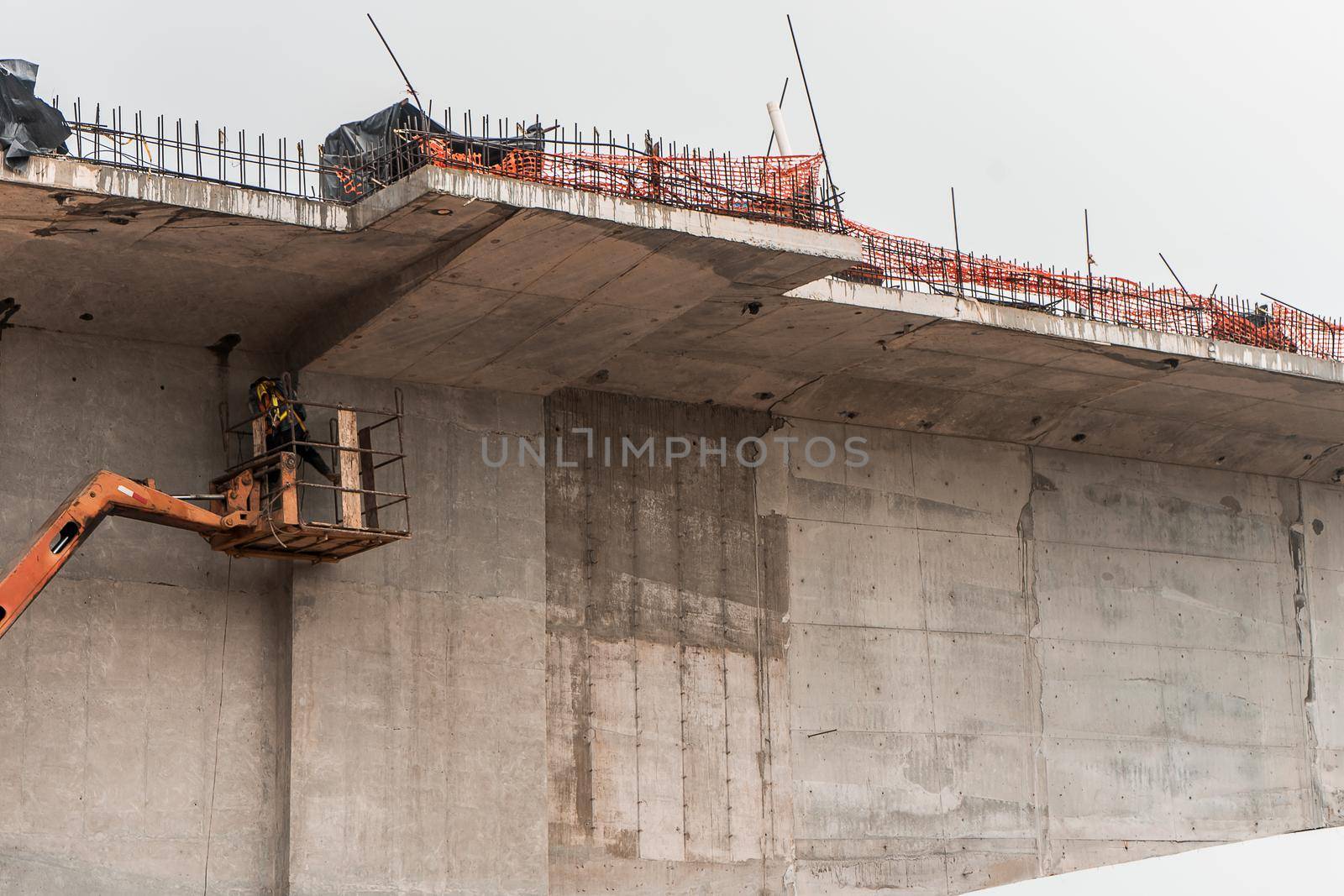 Latin worker doing repairs on a bridge mounted on a crane in Nicaragua, central america