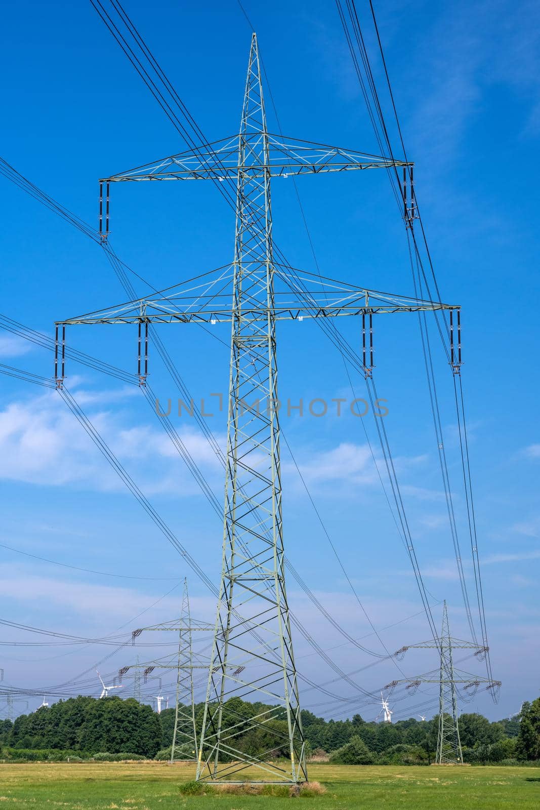 An electricity pylon in front of a blue sky seen in Germany