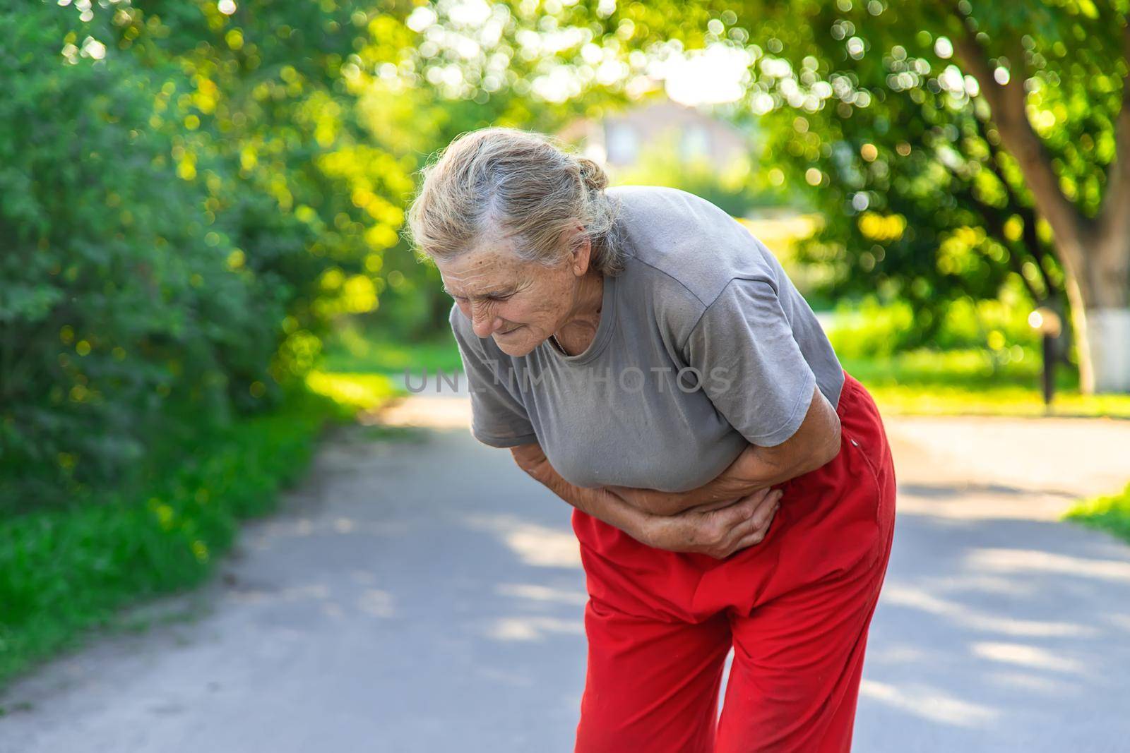 grandmother has a stomach ache on the road. Selective focus. people.