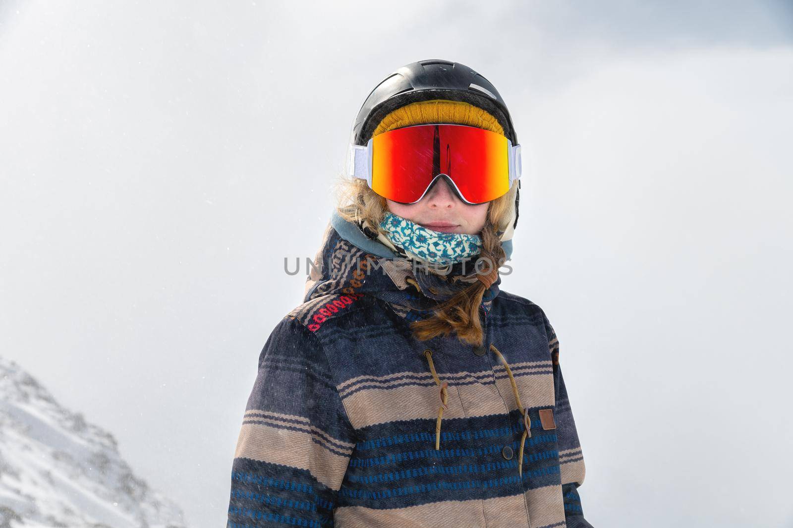 Macro portrait. Young adult woman, snowboarder or skier in a snowy winter on a mountain slope.