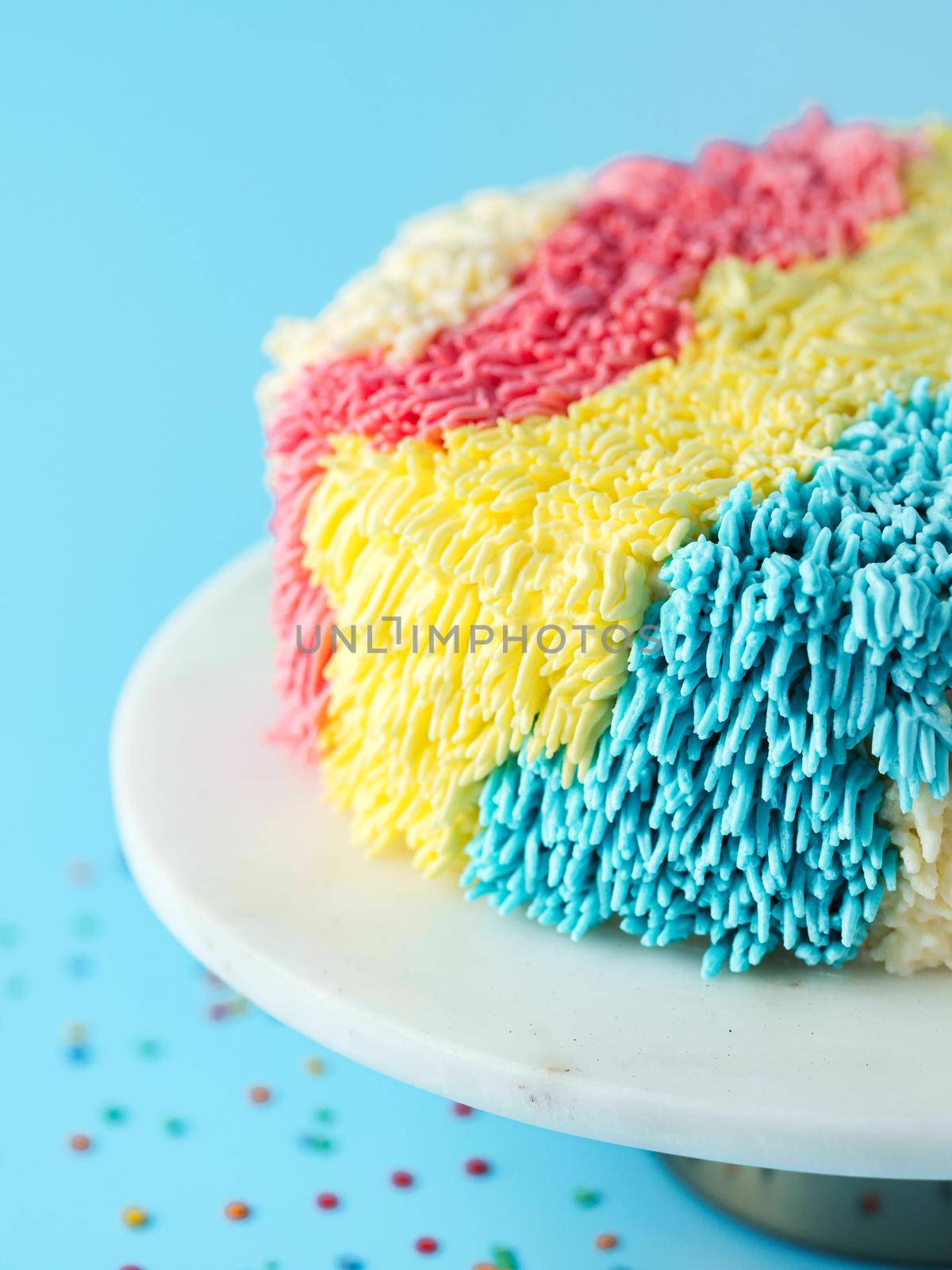 Colorful shag cake on blue background, copy space by fascinadora