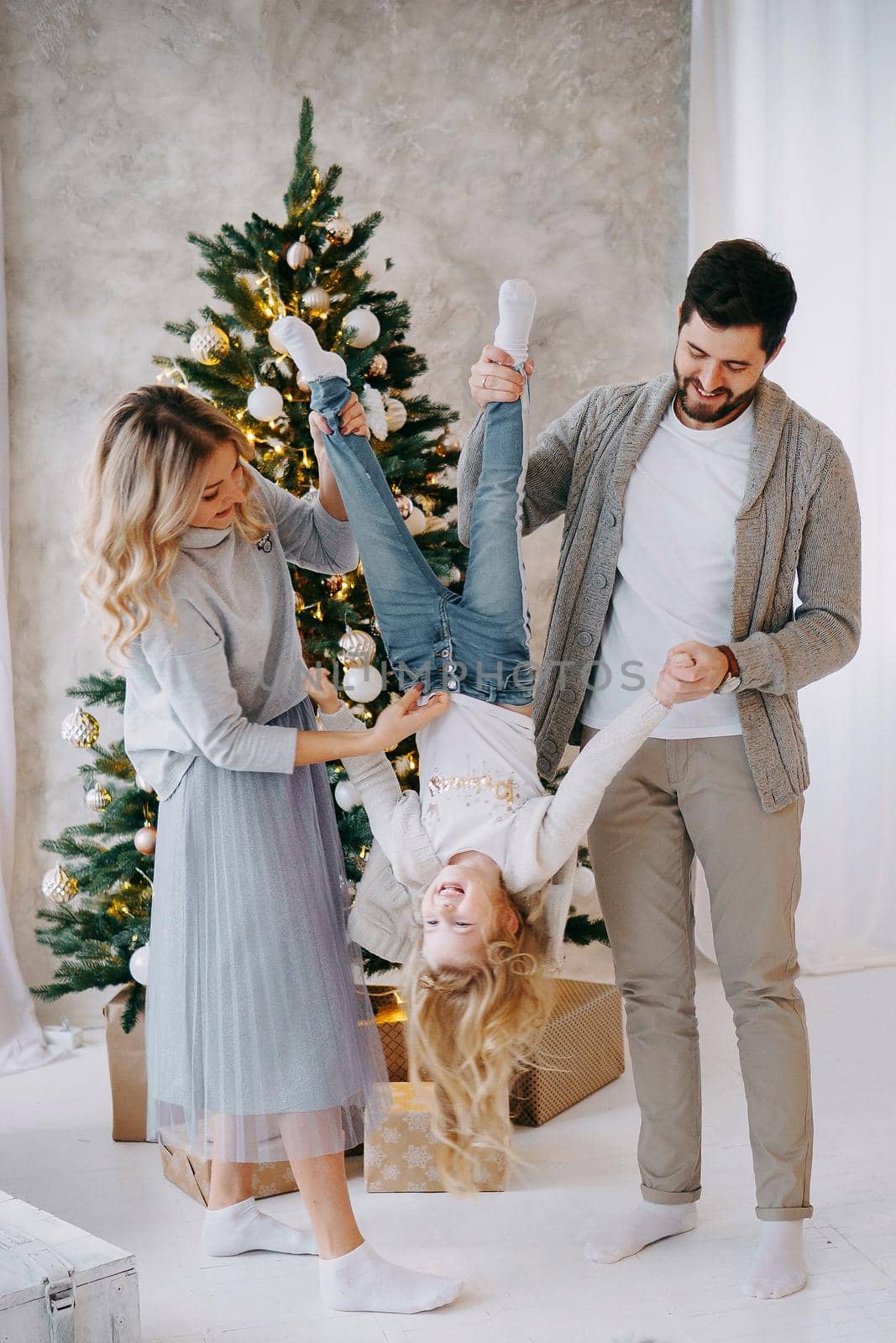 Happy family: mom, dad and pet. Family in a bright New Year's interior with a Christmas tree.