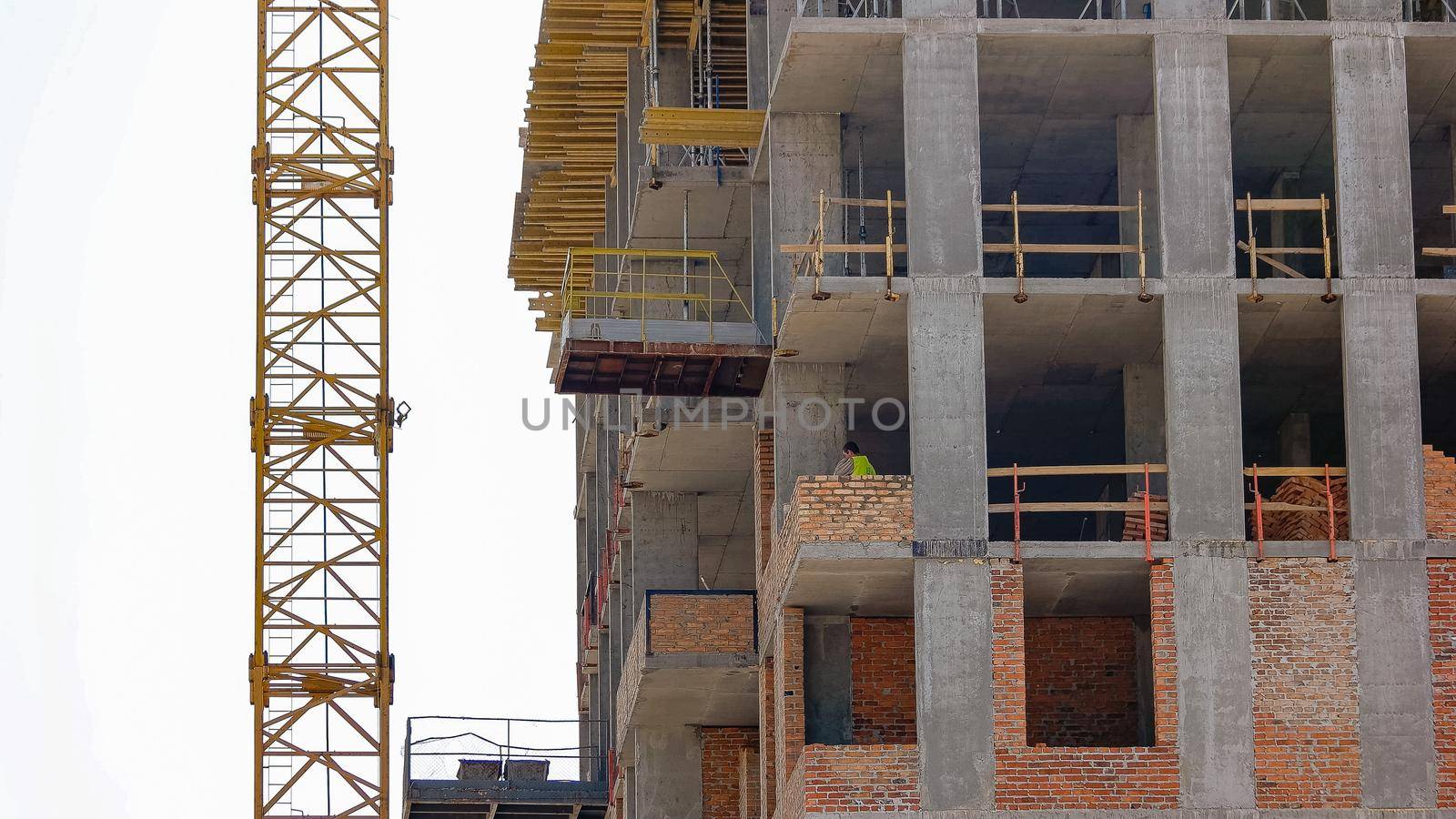 Worker in the building smears up cement on the bricks. Stirring up concrete.