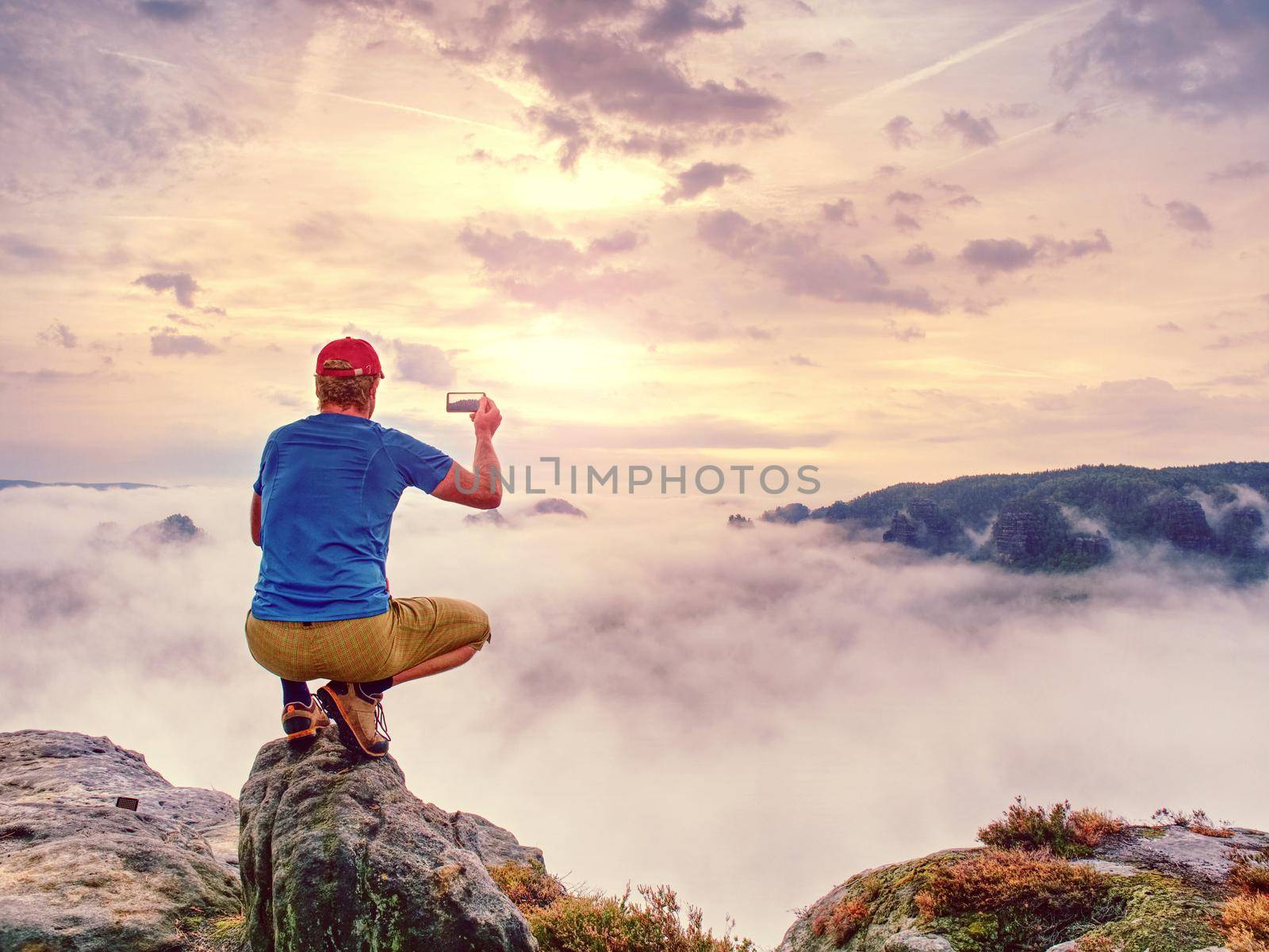 Blogger taking photo by smartphone of fall sunset mountains  by rdonar2