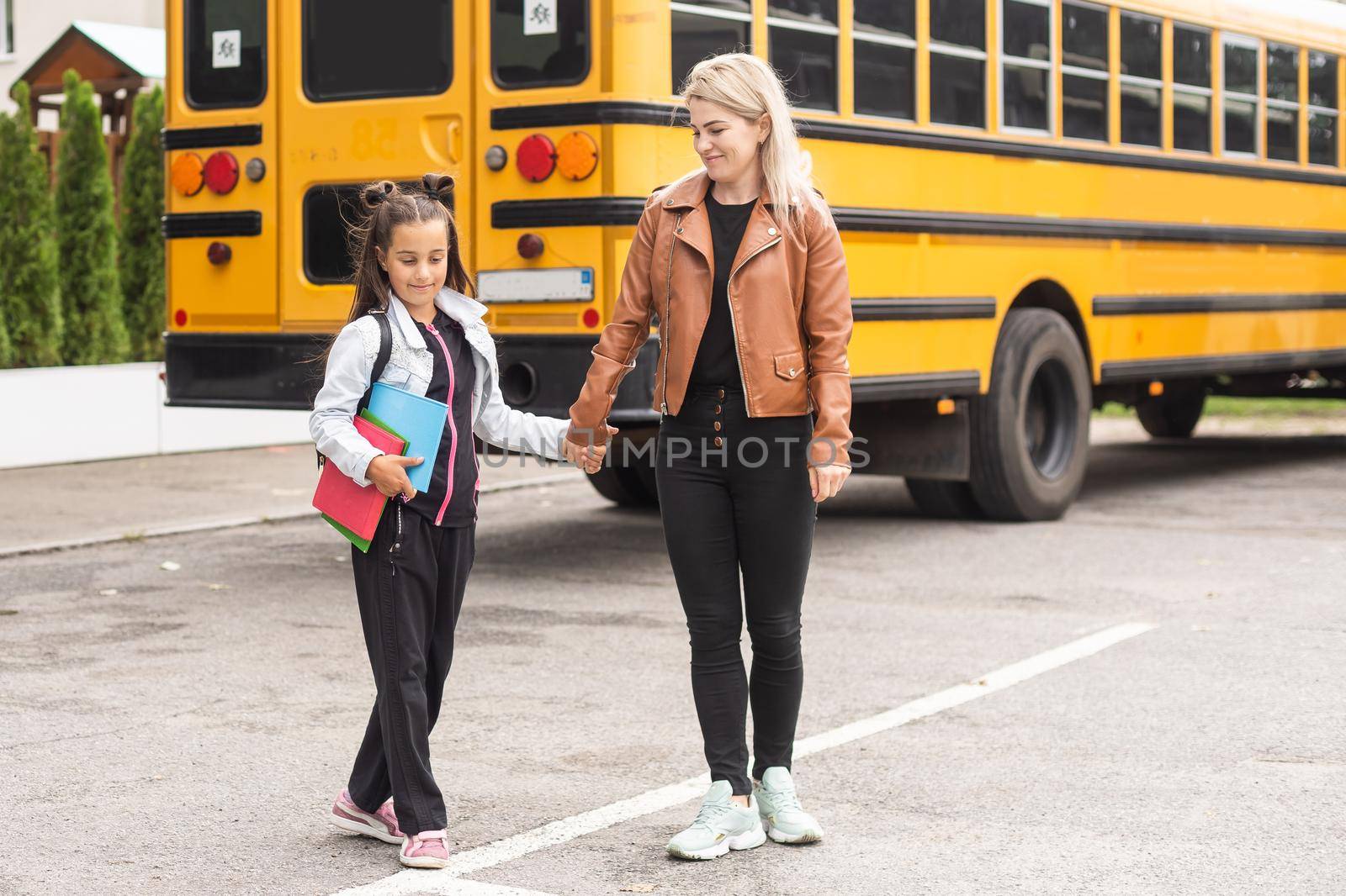 first day at school. mother leads a little child school girl.