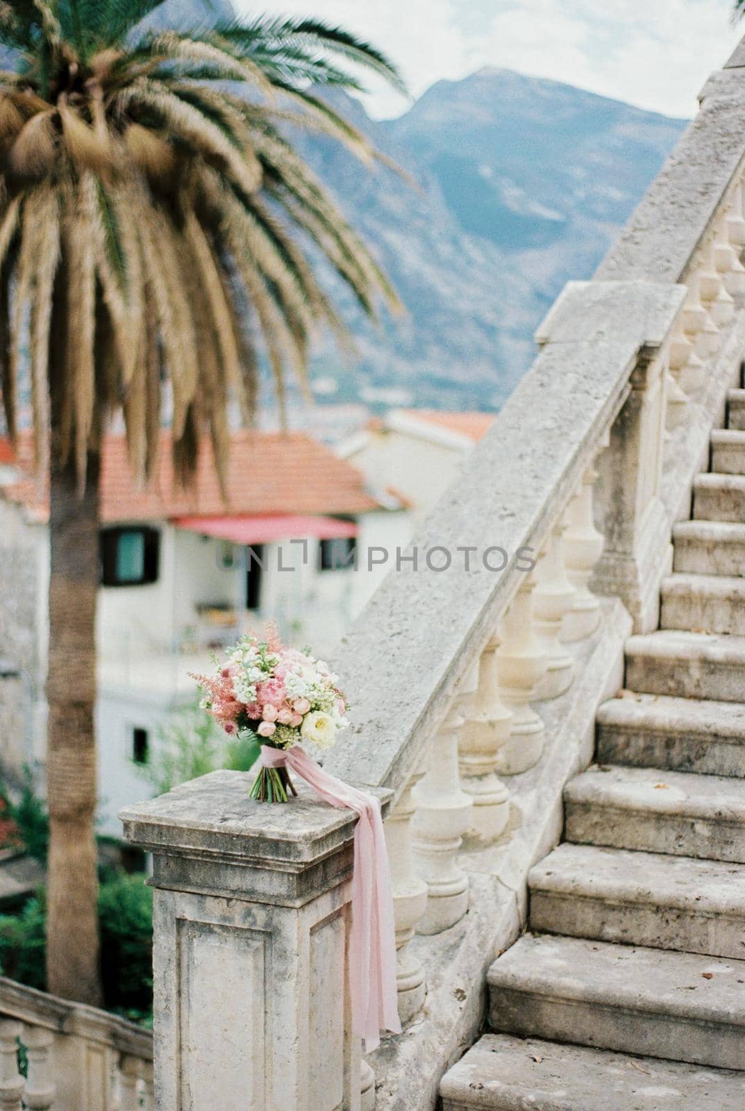 Bouquet of flowers stands on a marble balustrade near the steps. High quality photo