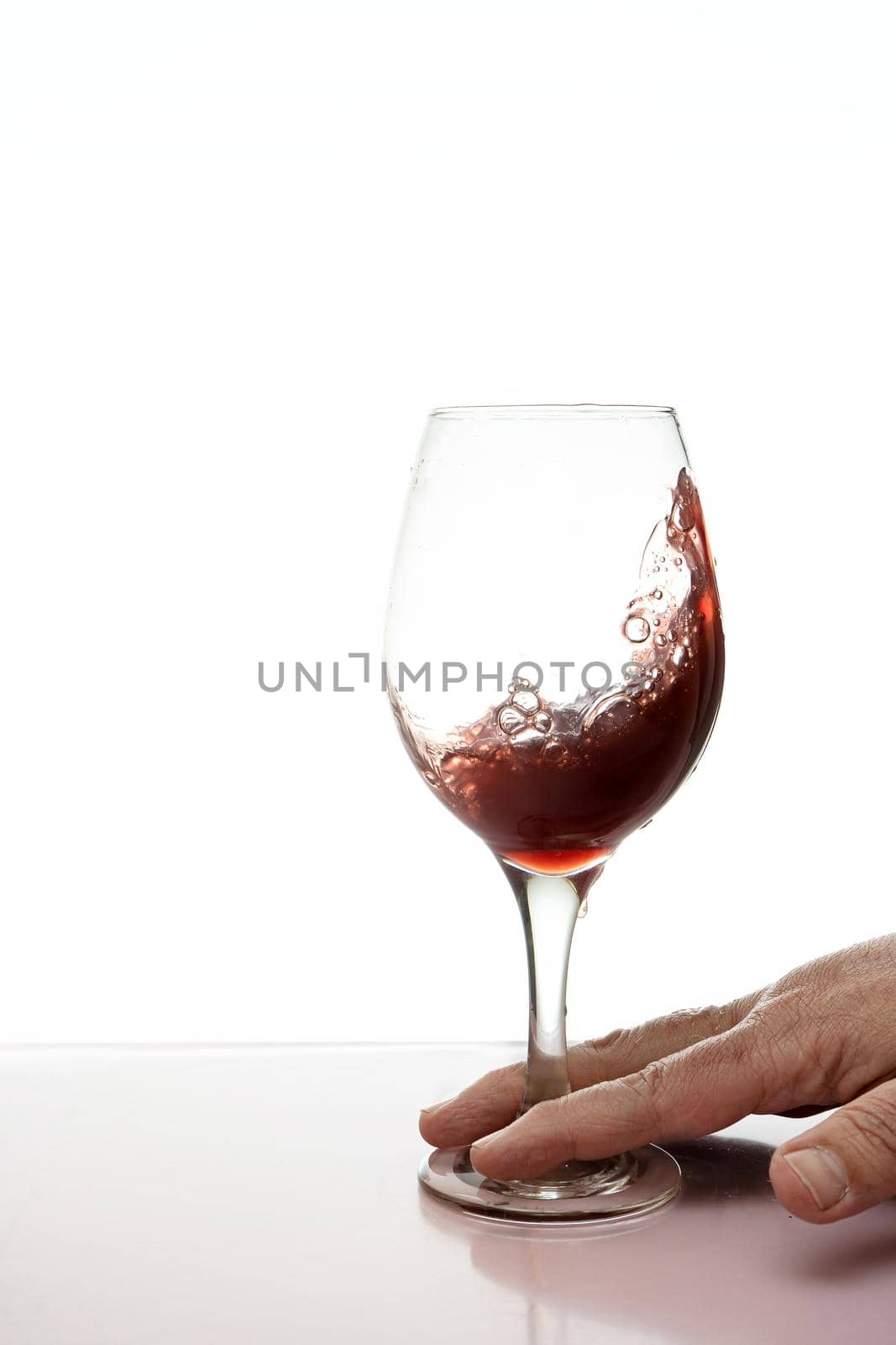 Glass of red wine splashing isolated. by hdcaputo