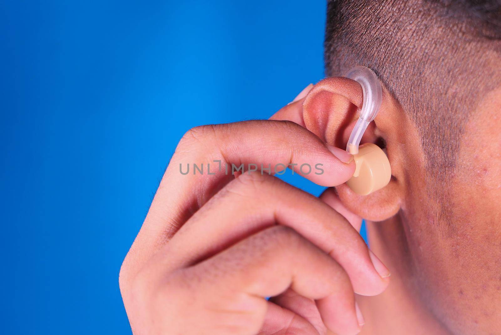 Hearing aid concept, a young man with hearing problems