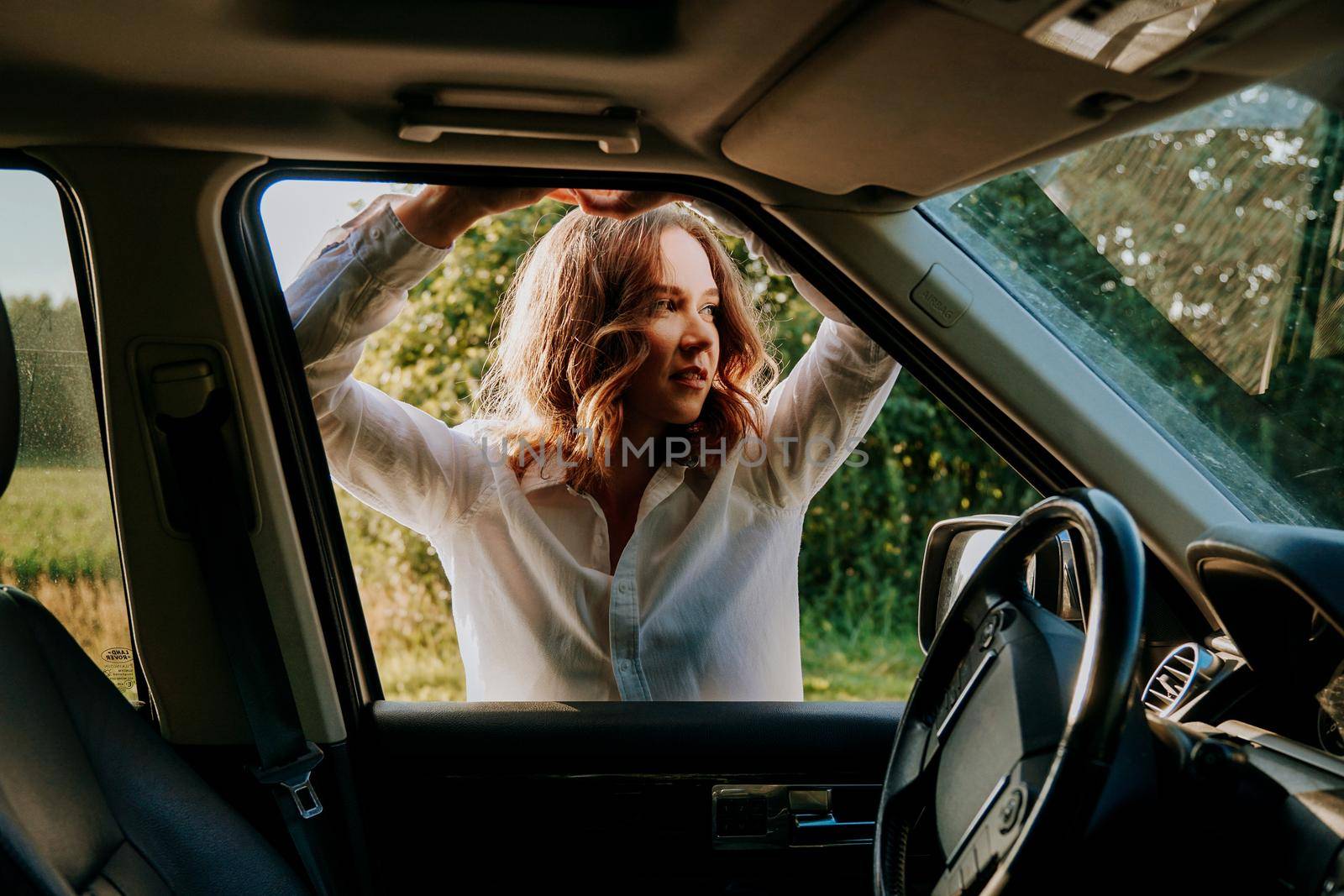 Woman in car travel relaxing and enjoying peace and silence of beautiful nature landscape. Woman in the car window. Trips and travels out of town