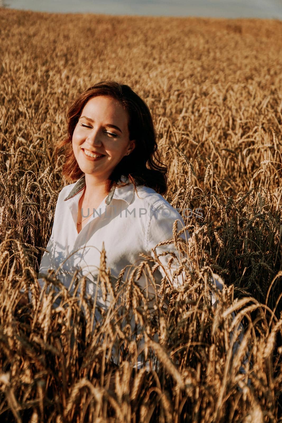 Summer nature, summer holidays, vacation and people concept. Close up of happy young woman in the ears of a rye field